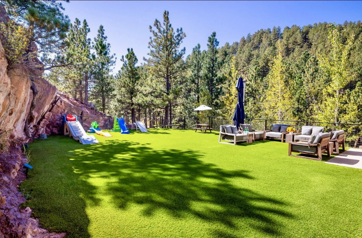 A level stretch of turf creates a usable lawn area, while custom Marpa landscaping softens the edges and ties the yard into the surrounding hillside.