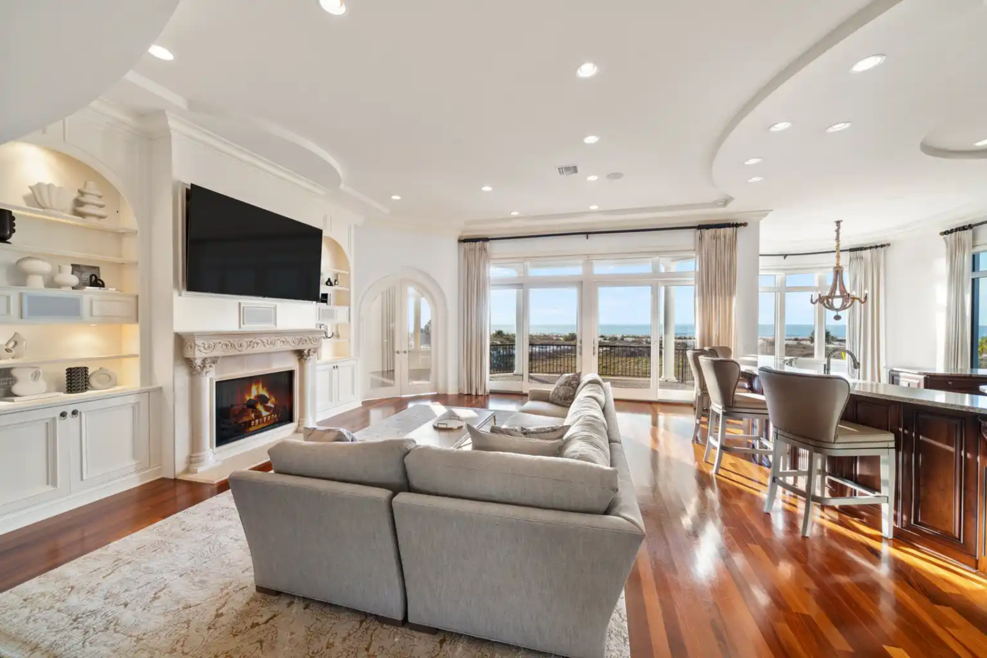 Floor-to-ceiling windows stretch across the room, pulling in natural light and keeping the Gulf in constant view.
