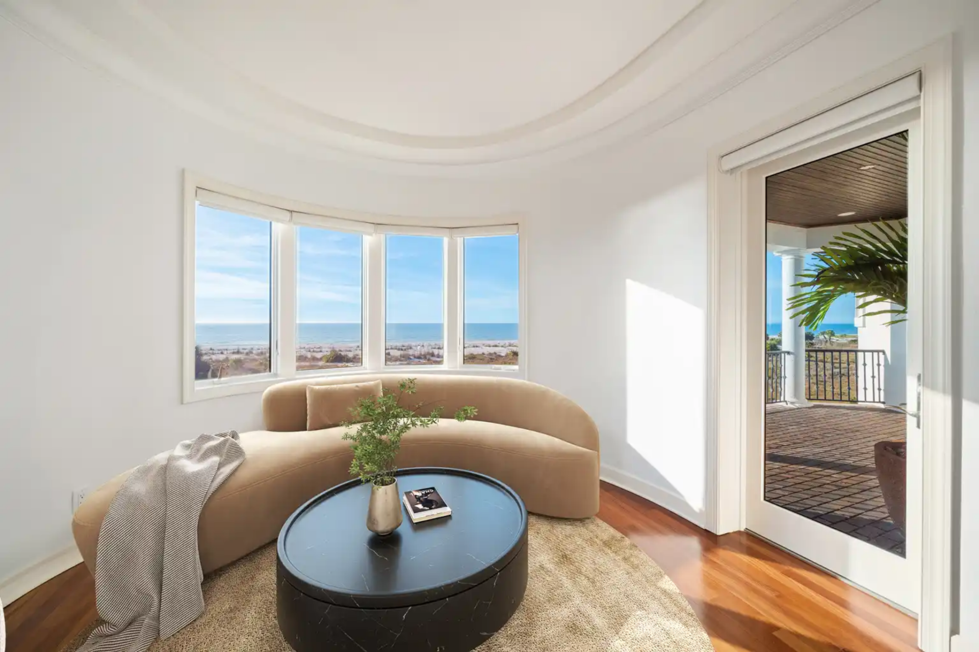 Sitting area curves along glass windows next to a door leading to a terrace.
