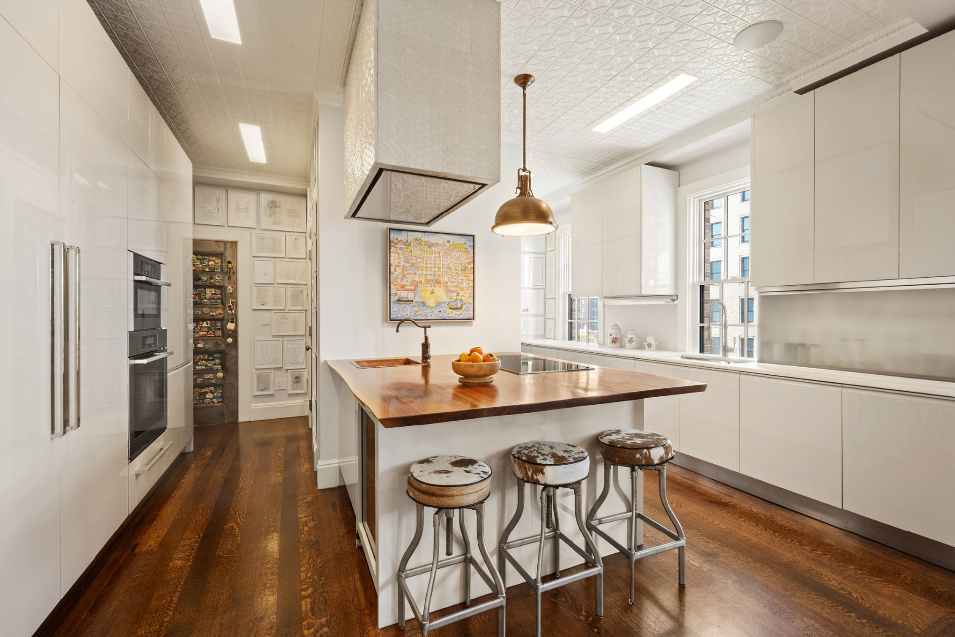 Following the hall, the oversized eat-in kitchen opens up as a bright, highly functional space with marble and walnut countertops lining the walls and center island.