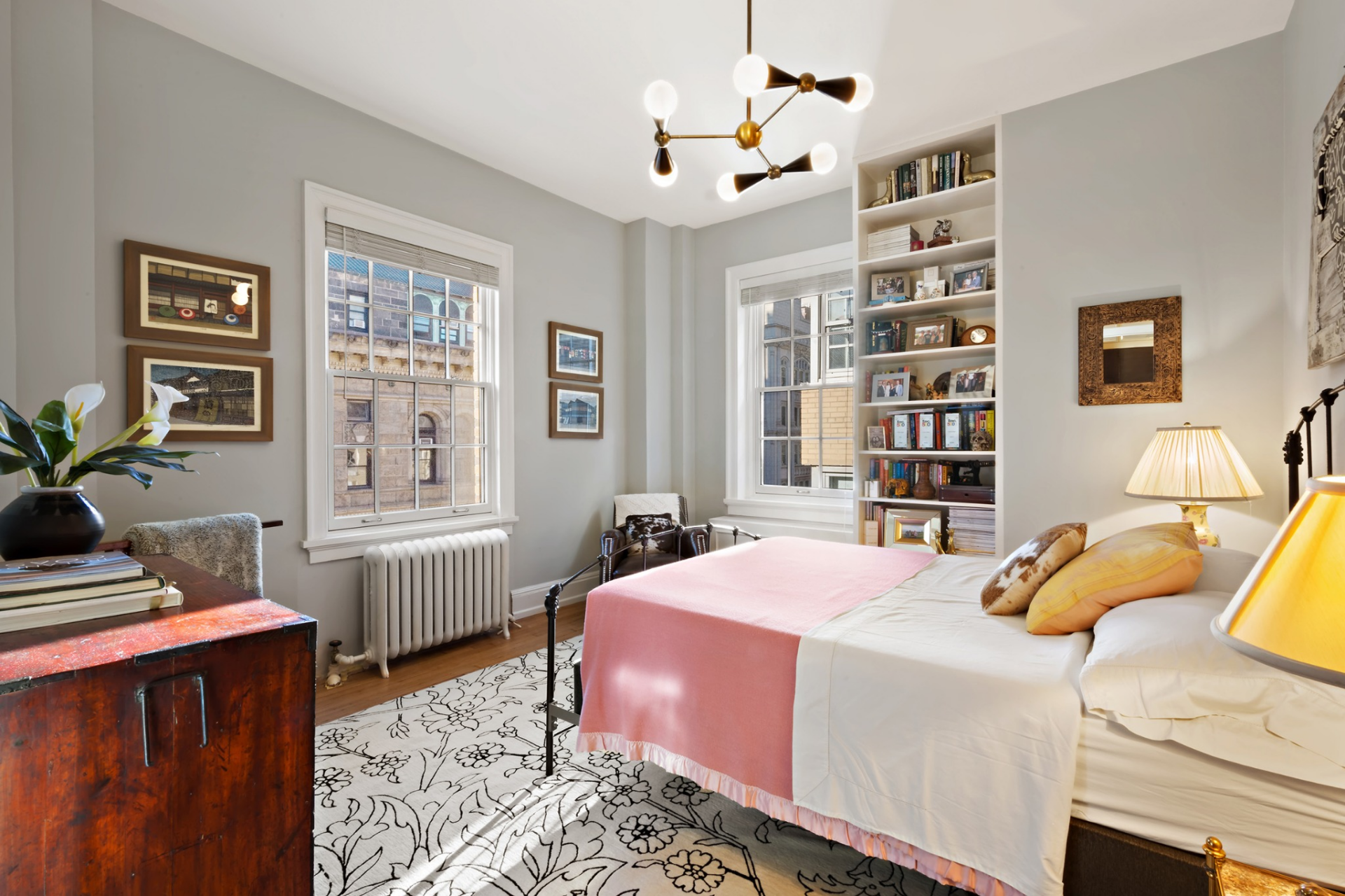 The first bedroom features custom built-in shelving that adds books, personal objects, and framed art to the room. 
