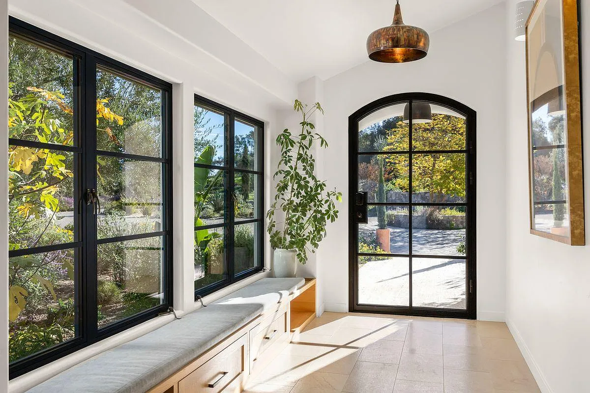 The interiors unfold gently from the entry, with warm plaster walls, stone floors, and thoughtful sightlines that guide you forward.