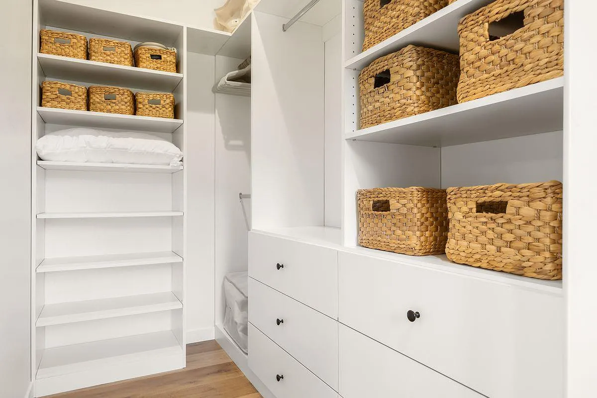 Completing the secondary suite is the closet which features built-in shelving, drawers, and hanging space arranged in an efficient layout.