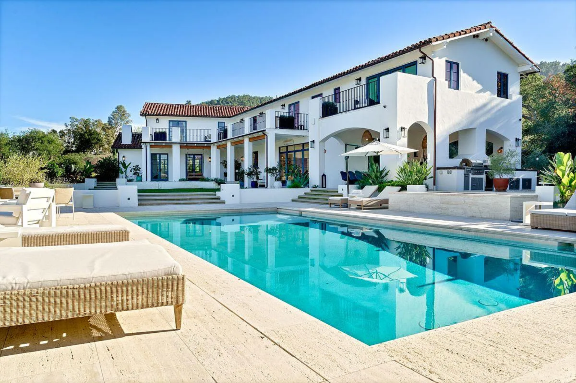 The resort-style saltwater pool sits on the main terrace, framed by multiple lounge areas and open sightlines back to the house.