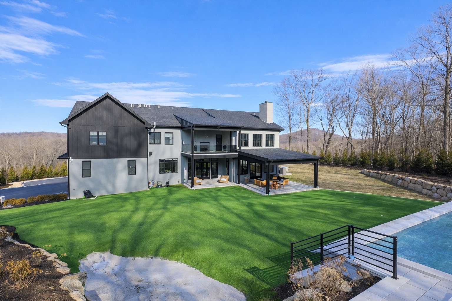 Between the house and the pool sits the artificial turf putting green, complete with multiple holes and a sculpted sand trap that gives the space a true short-game feel while also providing enough space for defensive drills.