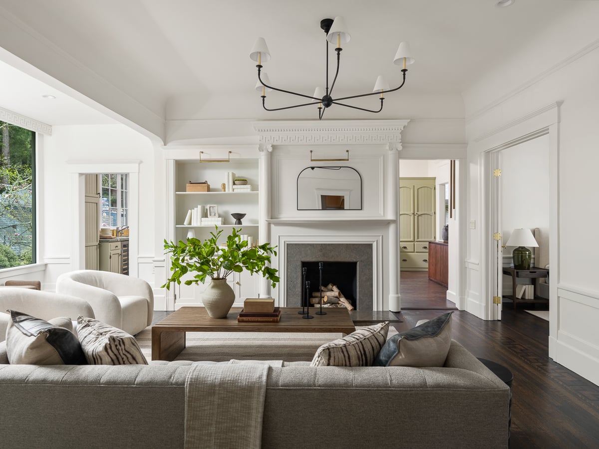 Walking into the home, the layout opens directly into a bright, centered great room anchored by a detailed wood-burning fireplace. 