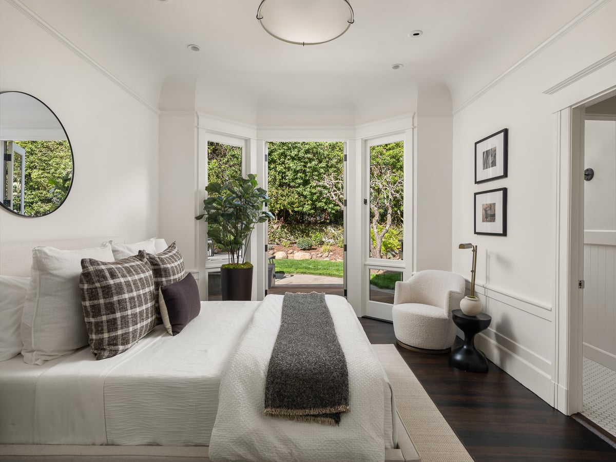 One of the guest bedrooms on the main level opens directly out to the garden through a set of glass-paneled doors.