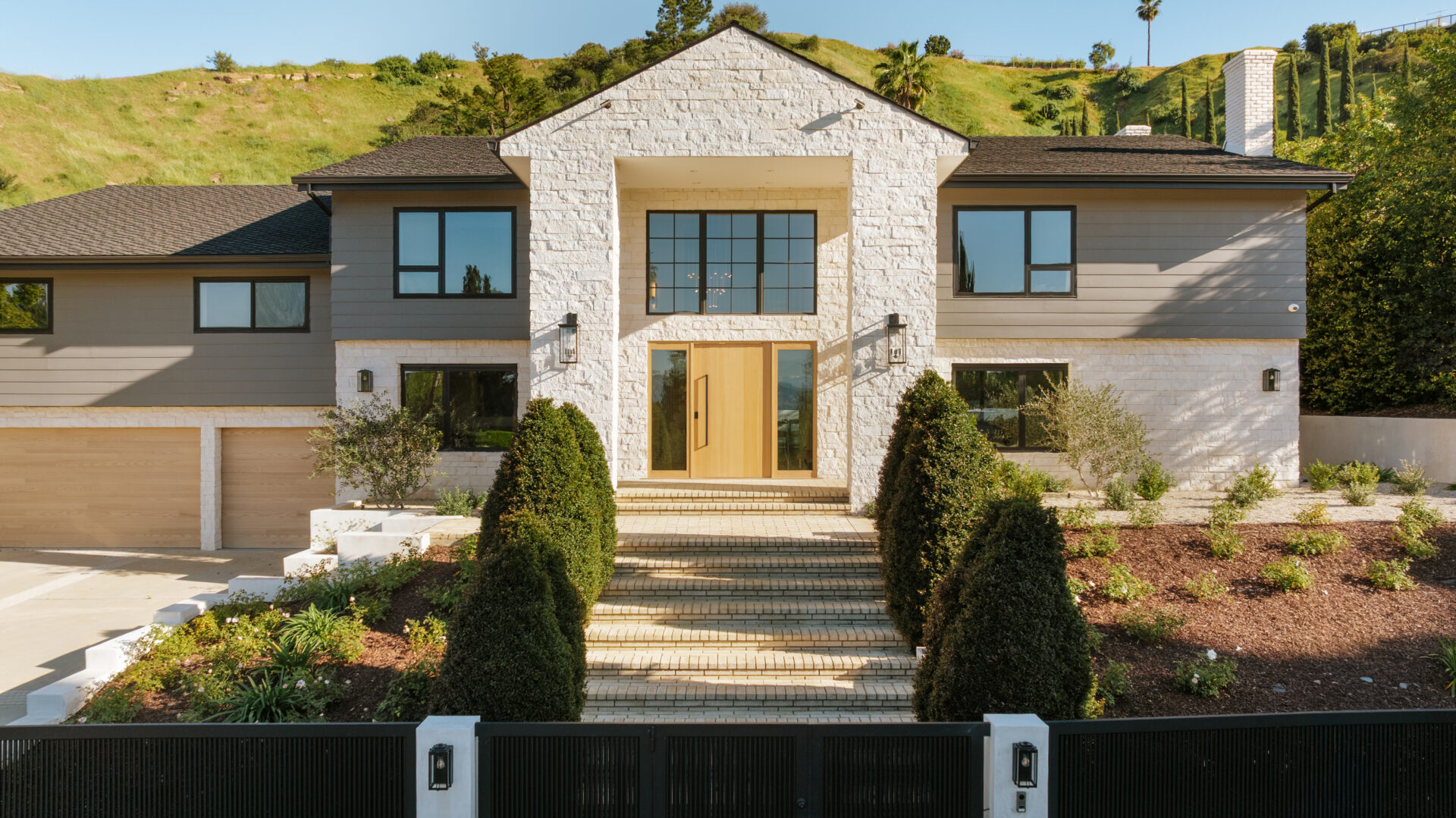 Today, the 5,492-square-foot home has been fully reimagined, trading its original red brick exterior and columned look for a more modern design with white brick and grey paneling.