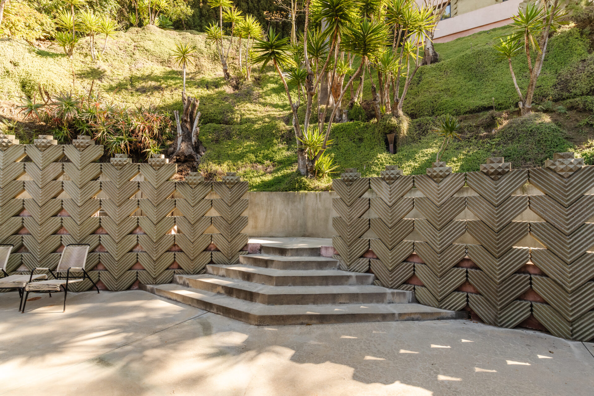 Repeating chevron forms appear throughout the property, giving the design both a structural rhythm and a symbolic weight.