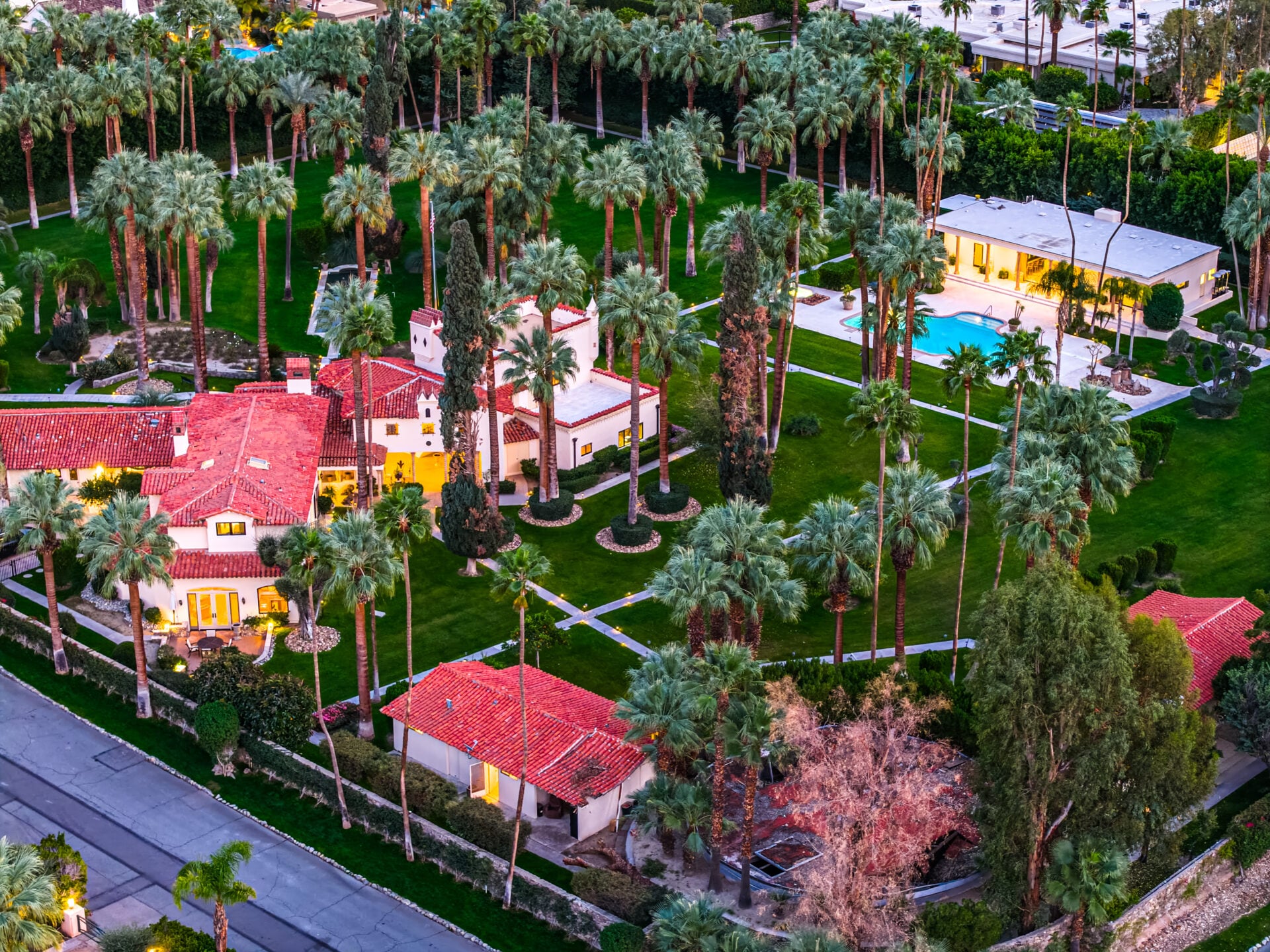 The property includes four separate residences spread across the park-like setting, connected by pathways and gardens that create a private compound atmosphere.