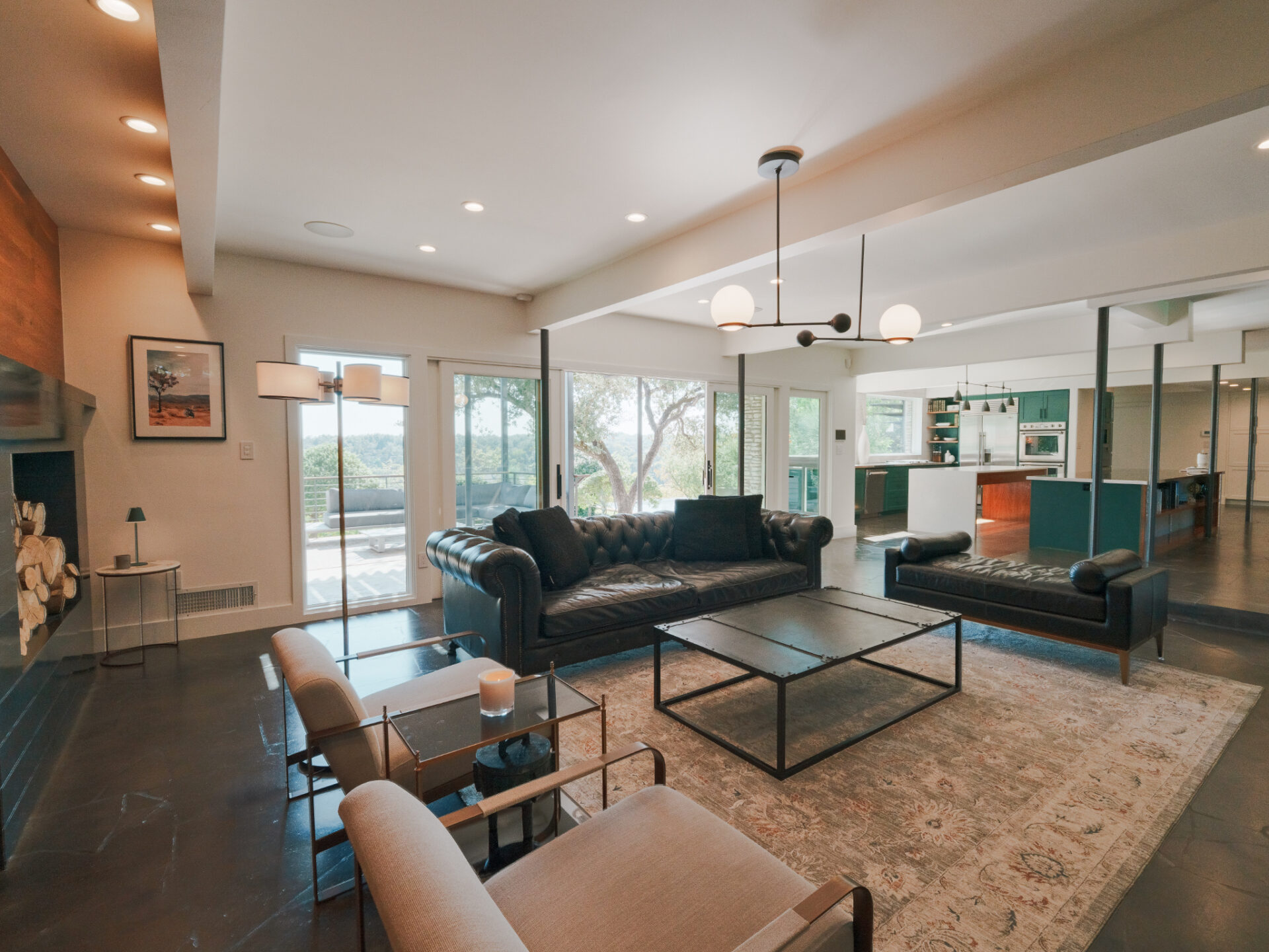The floor-to-ceiling panels stretch across the back of the space, framing sweeping hillside views and sliding open to a terrace that extends the living area outdoors.