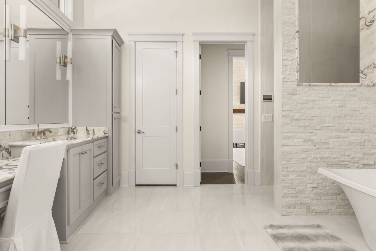 Across the room, a long double vanity with marble countertops and large mirrors provides generous counter space and storage.