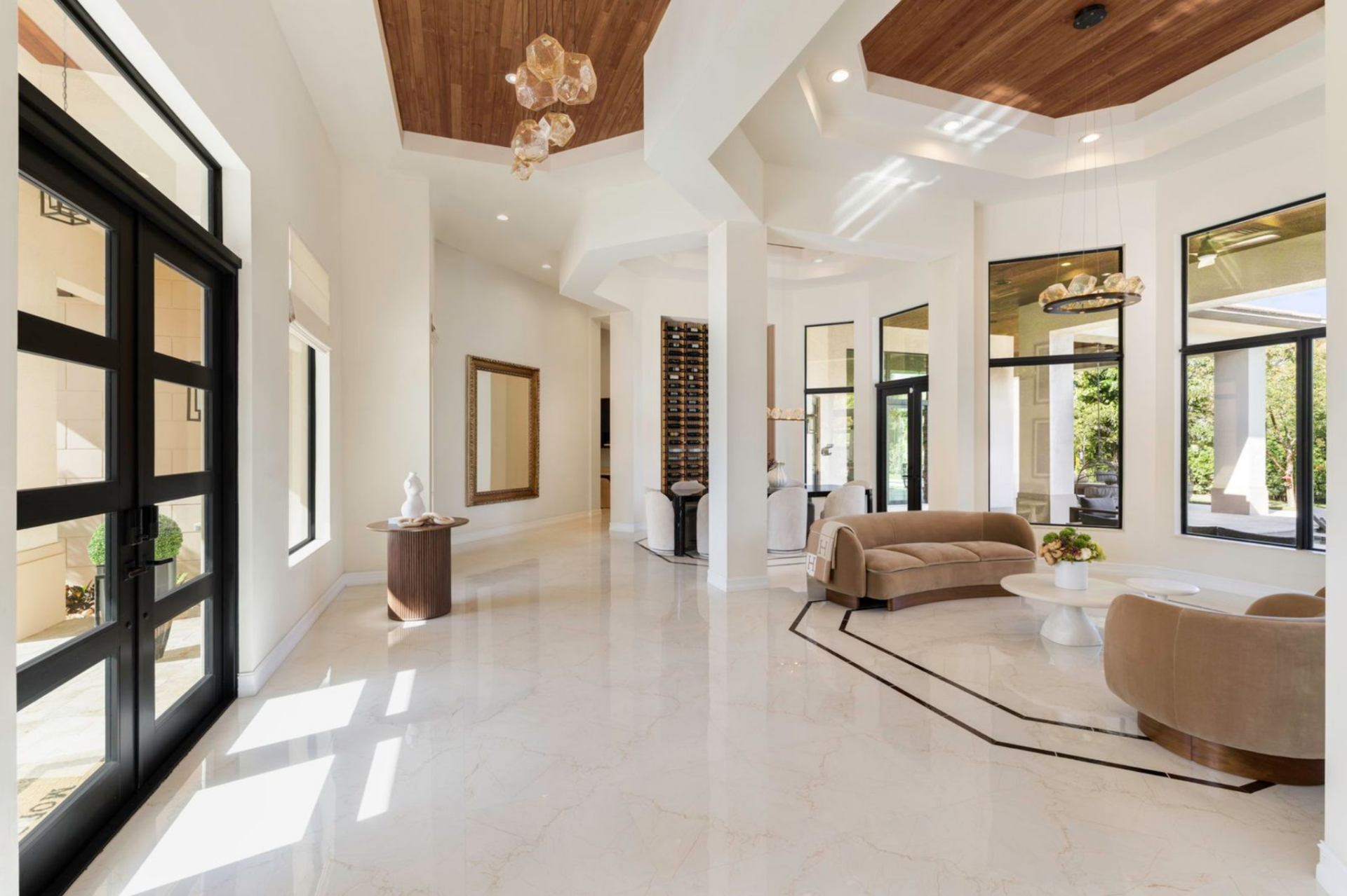 Tall columns and clean architectural lines guide the eye deeper into the house, where custom-built-ins and additional seating areas begin to unfold beyond the entry.