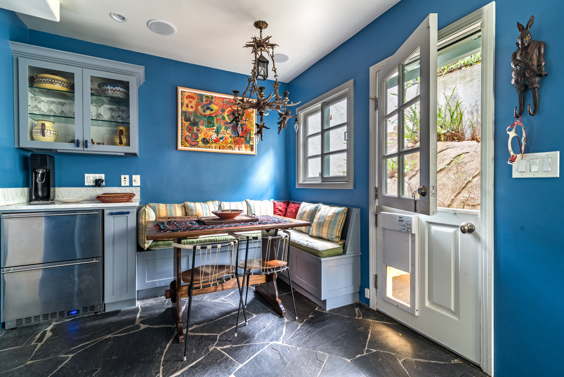 Just beside the kitchen, a cozy breakfast nook is built into the corner with a wraparound bench and a wooden dining table.