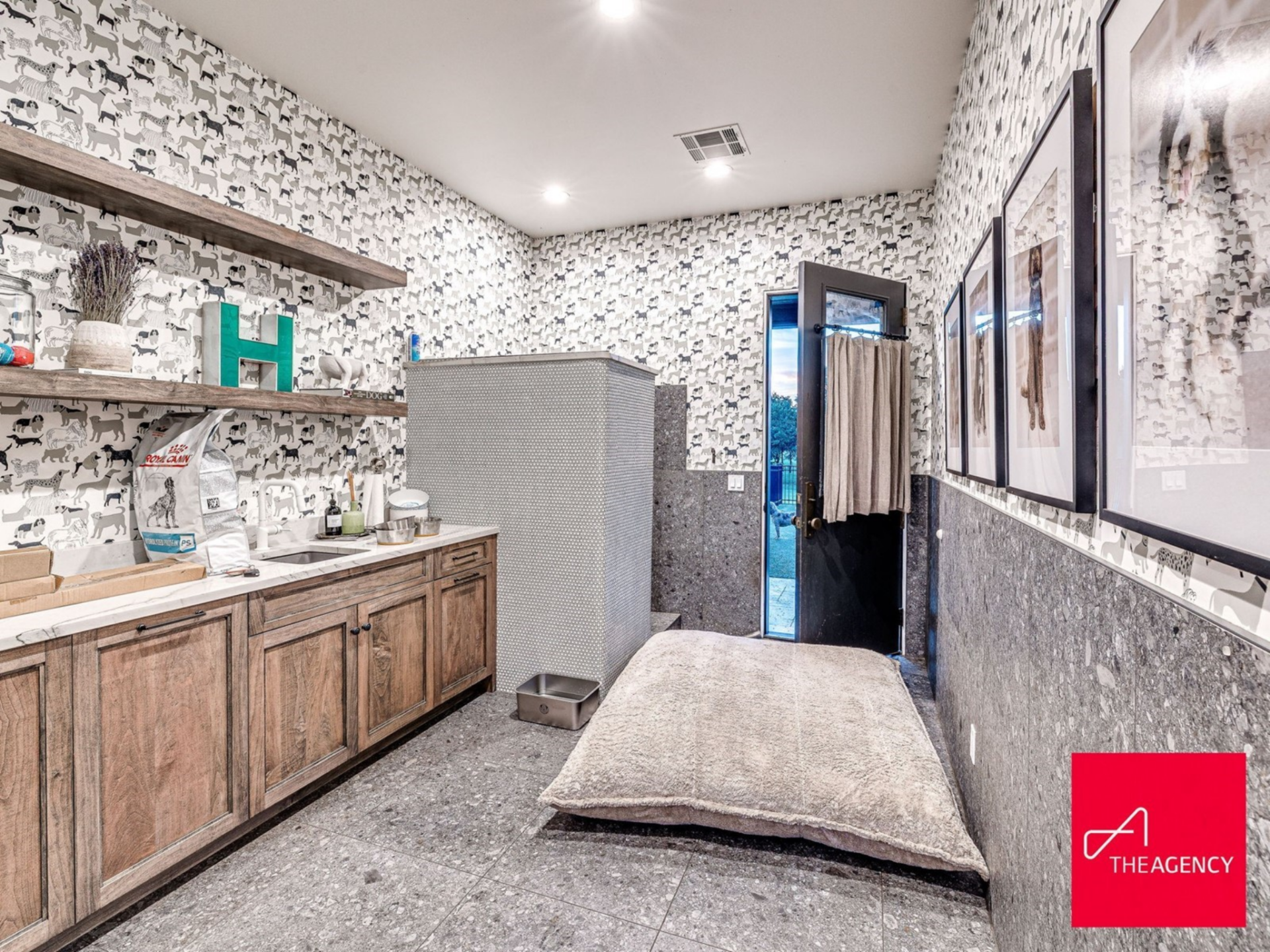Designed with durability in mind, the dog room features stone flooring, half-height granite walls, and playful dog-print wallpaper throughout.