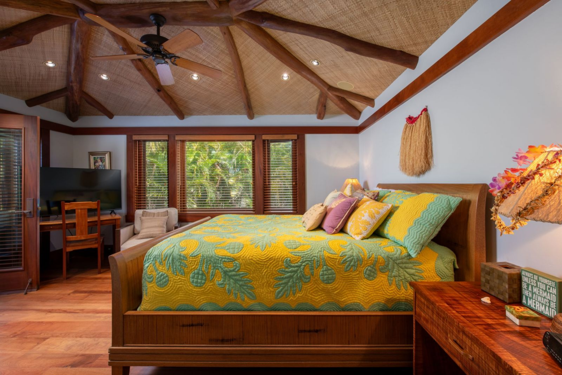 A third bedroom introduces brighter tones through patterned bedding and decorative accents while maintaining the same exposed beam ceiling design.
