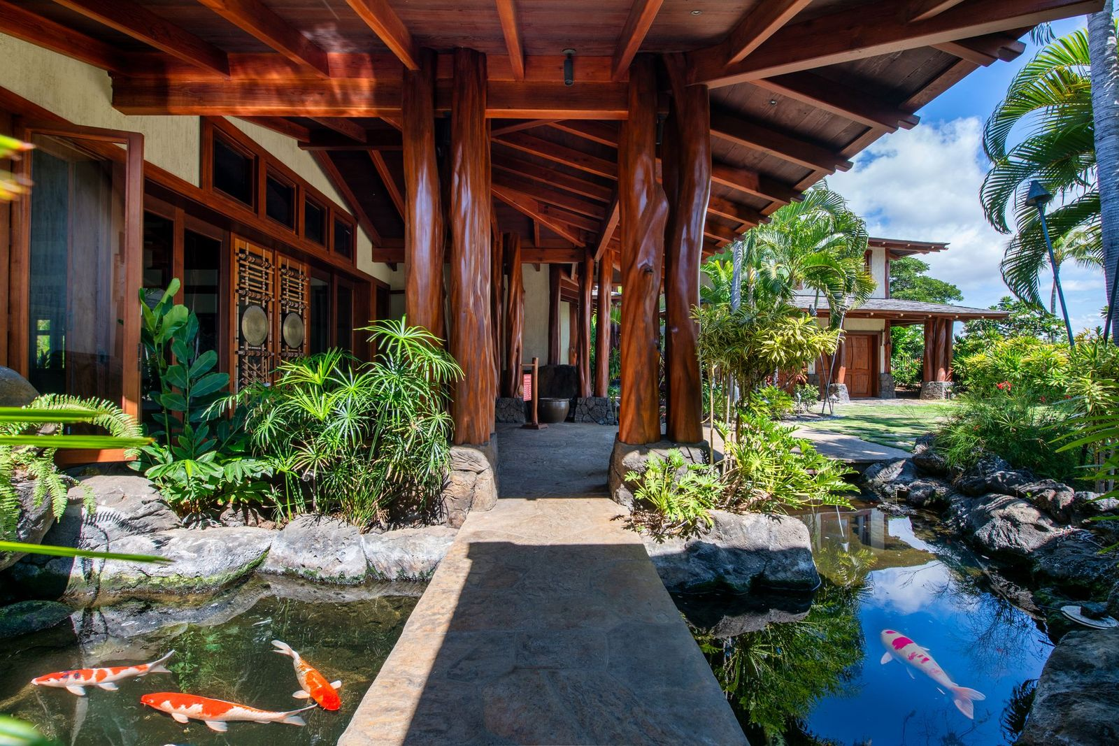 Koi ponds line a walkway to the front door.