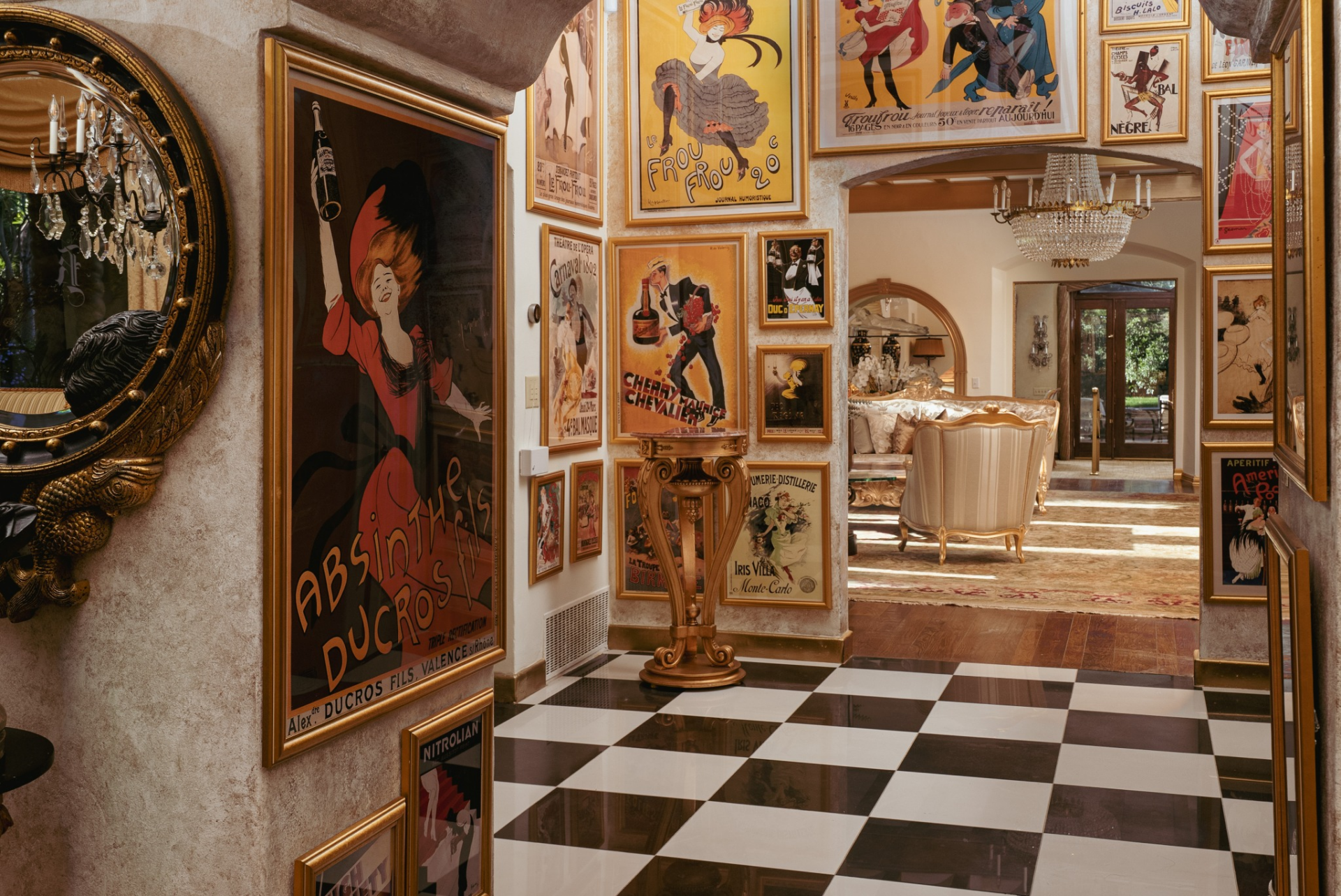 The space is surrounded by a striking gallery of framed vintage posters that climb nearly to the ceiling, transforming the entry into a curated display of art and history. 