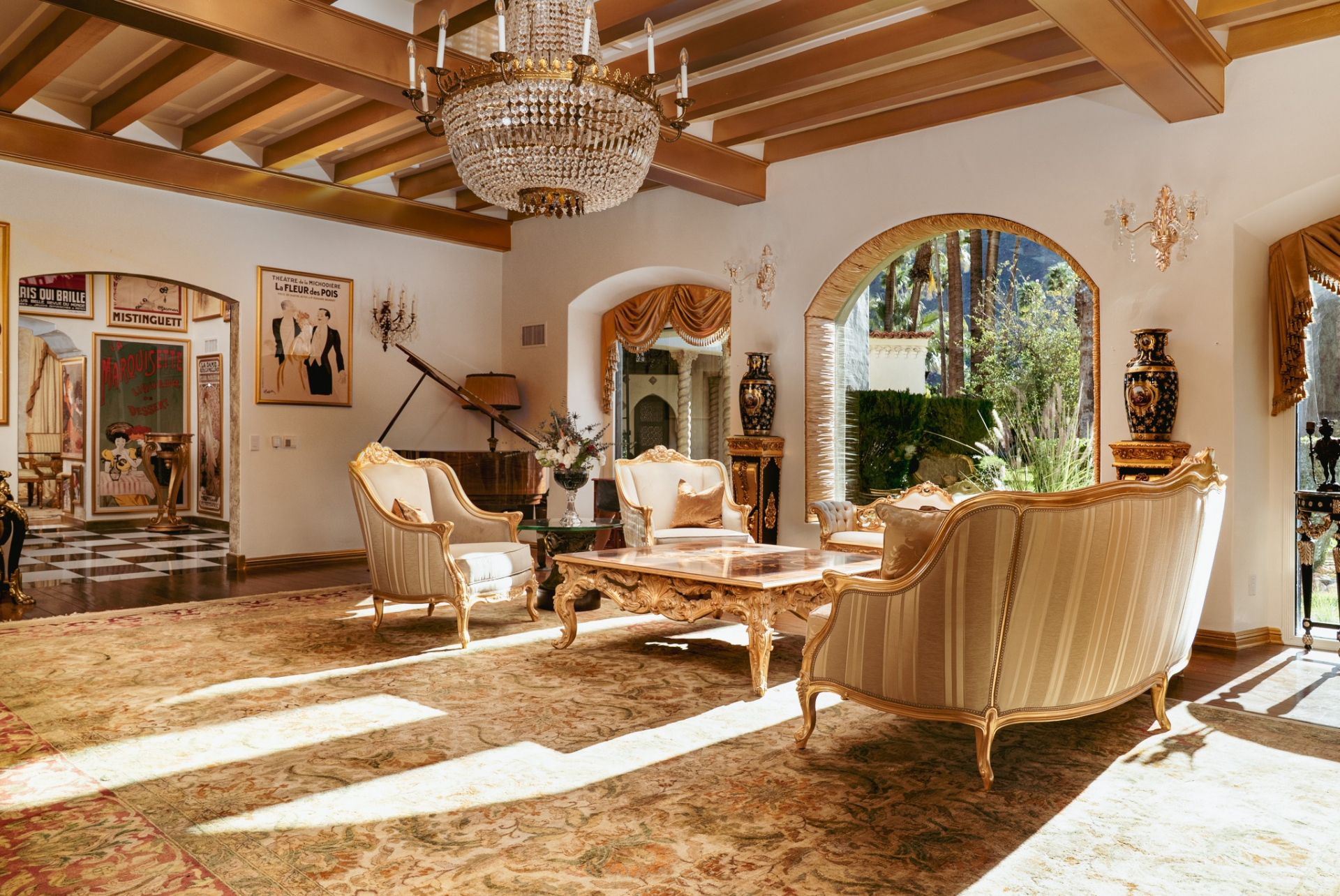 Antique furnishings, decorative vases, and a grand piano complete the room, reinforcing the residence’s European-inspired character and its emphasis on formal gathering spaces.