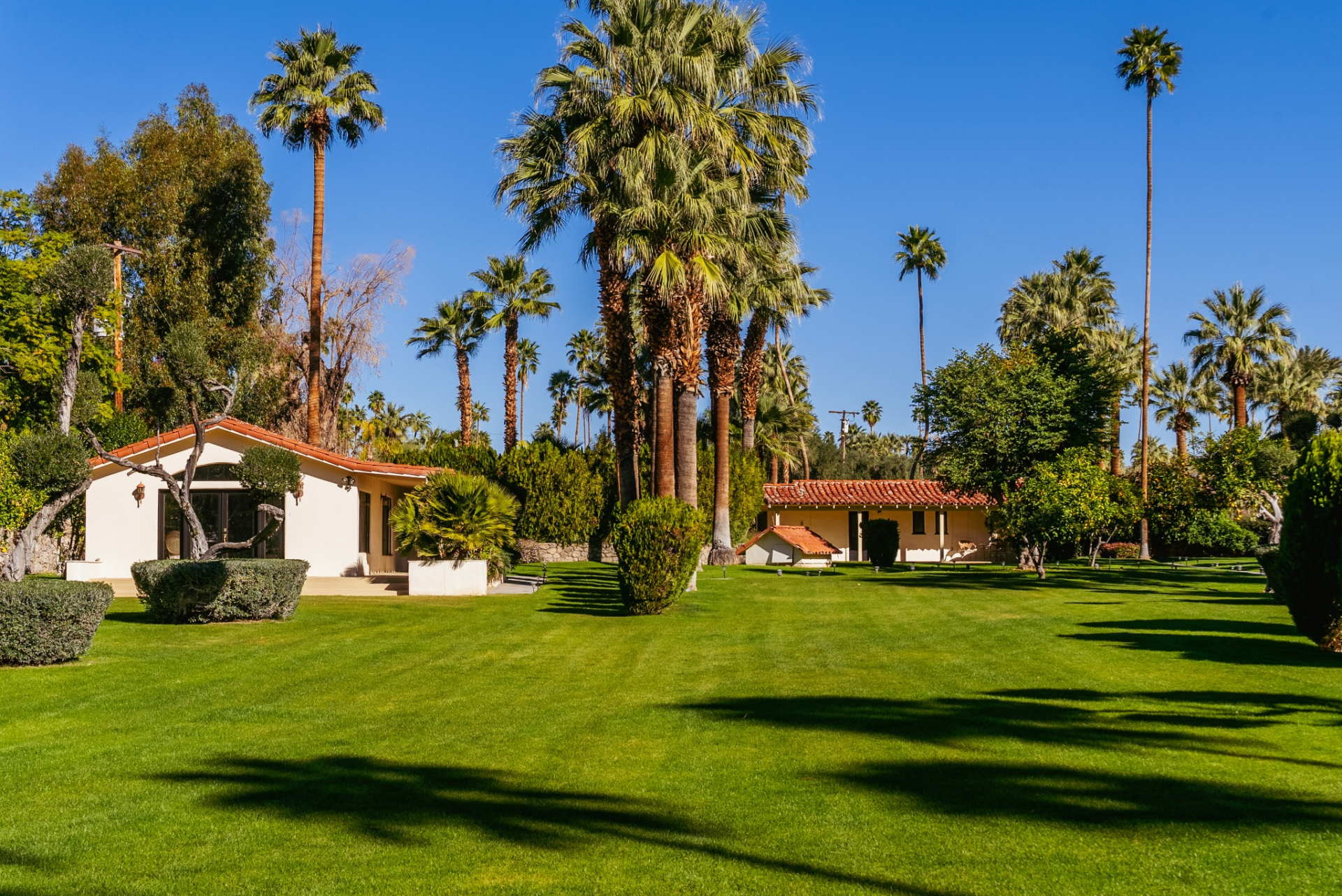 Elsewhere across the grounds, wide stretches of grass connect a collection of additional structures positioned throughout the estate.