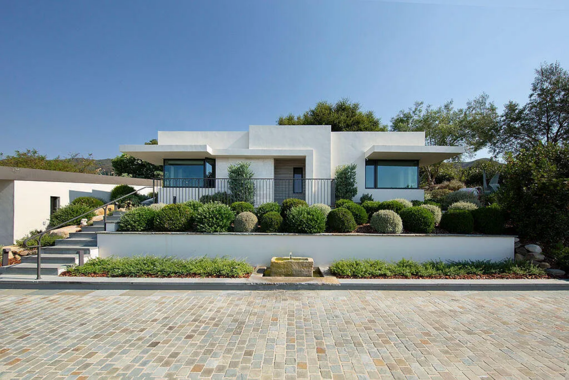 Across the courtyard from the main residence sits a separate guest house, offering a private space that mirrors the clean architectural lines and light-filled interiors of the main home. 