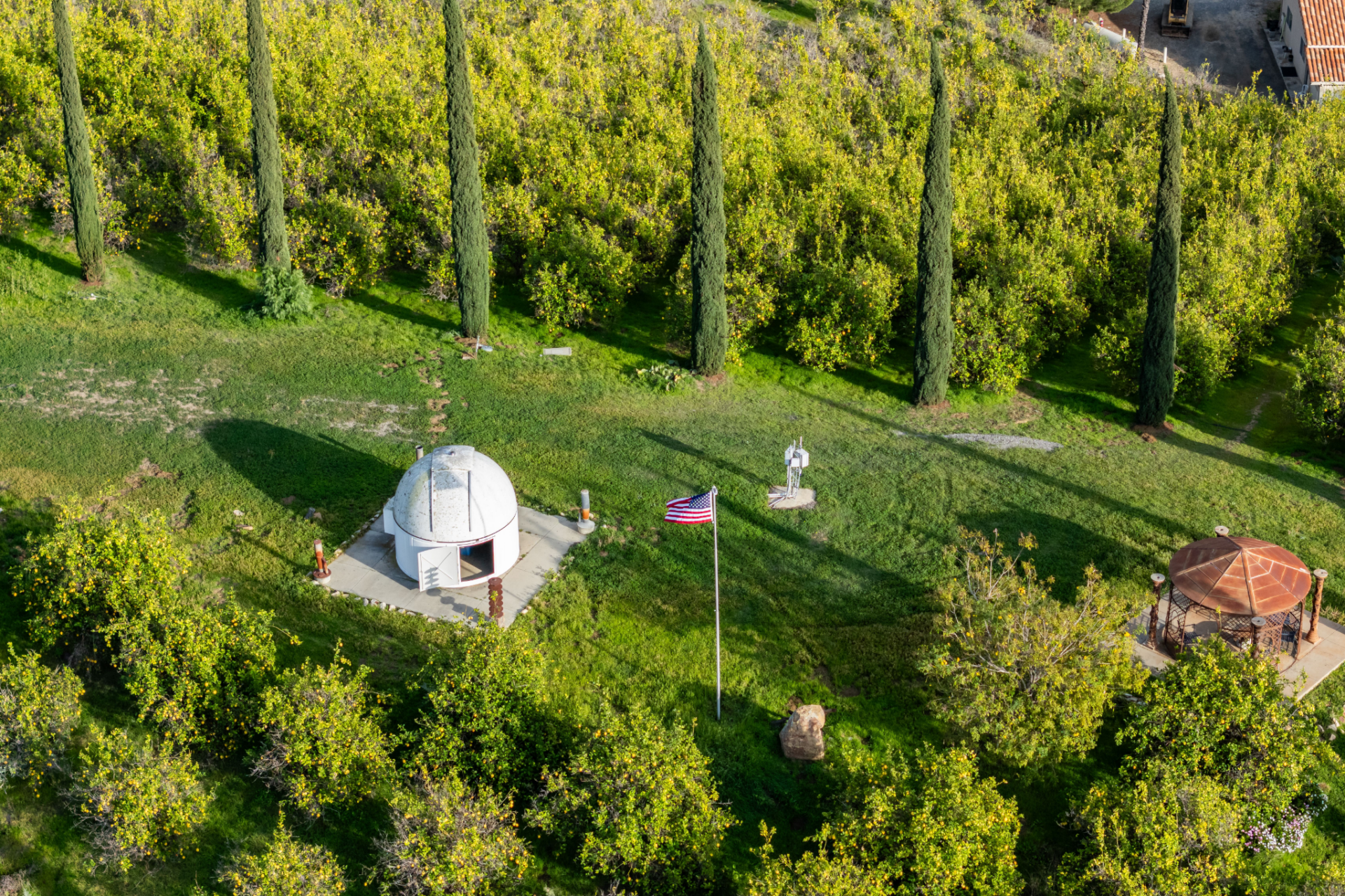 Further across the property, a small observatory dome sits on a grassy hillside, offering a dedicated space for stargazing beneath the rural night sky. 