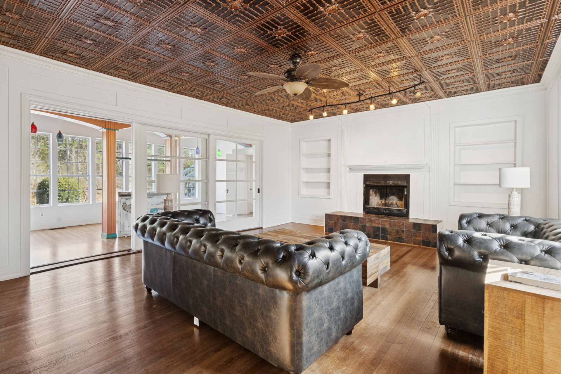 Overhead, a patterned tin ceiling adds texture and contrast, drawing attention upward and giving the room a more detailed finish. 