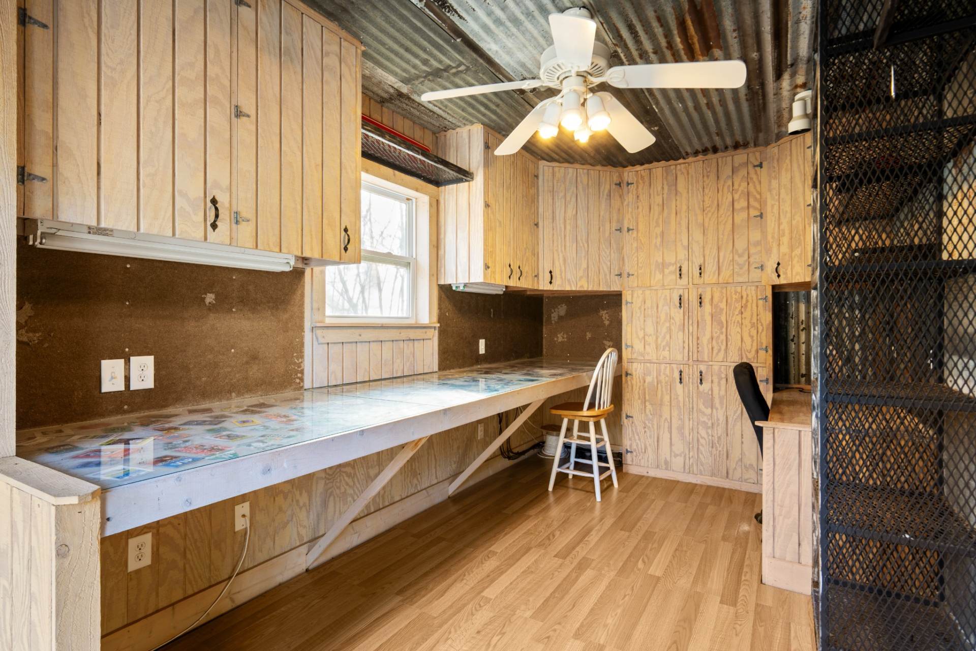 Completing the lower level is a dedicated office space, finished with wood-paneled walls and built-in cabinetry that runs along the perimeter. 
