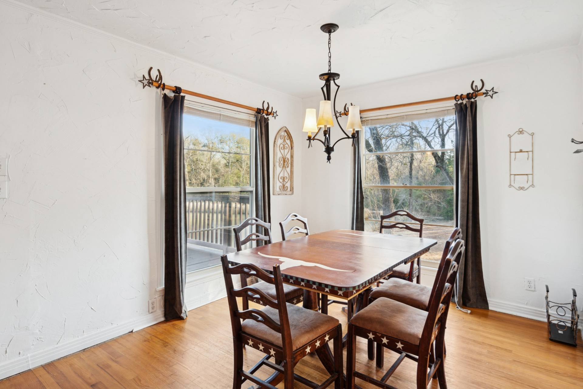 Placed in a corner near two large windows, the dining room is filled with natural light and views of the surrounding trees. 