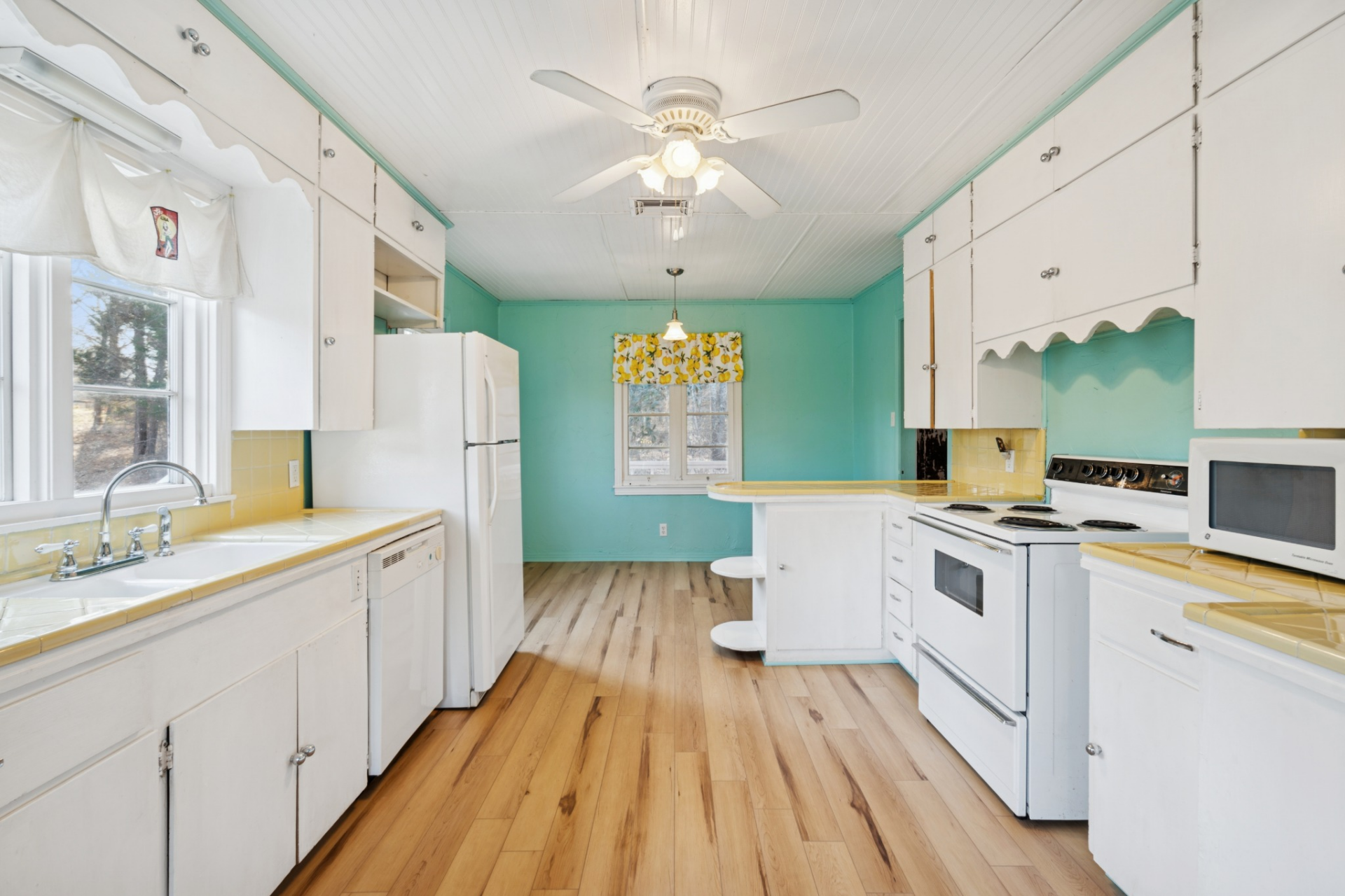 A small peninsula serves as a divider between the kitchen and breakfast nook, while the layout stretches vertically down both sides of the room.