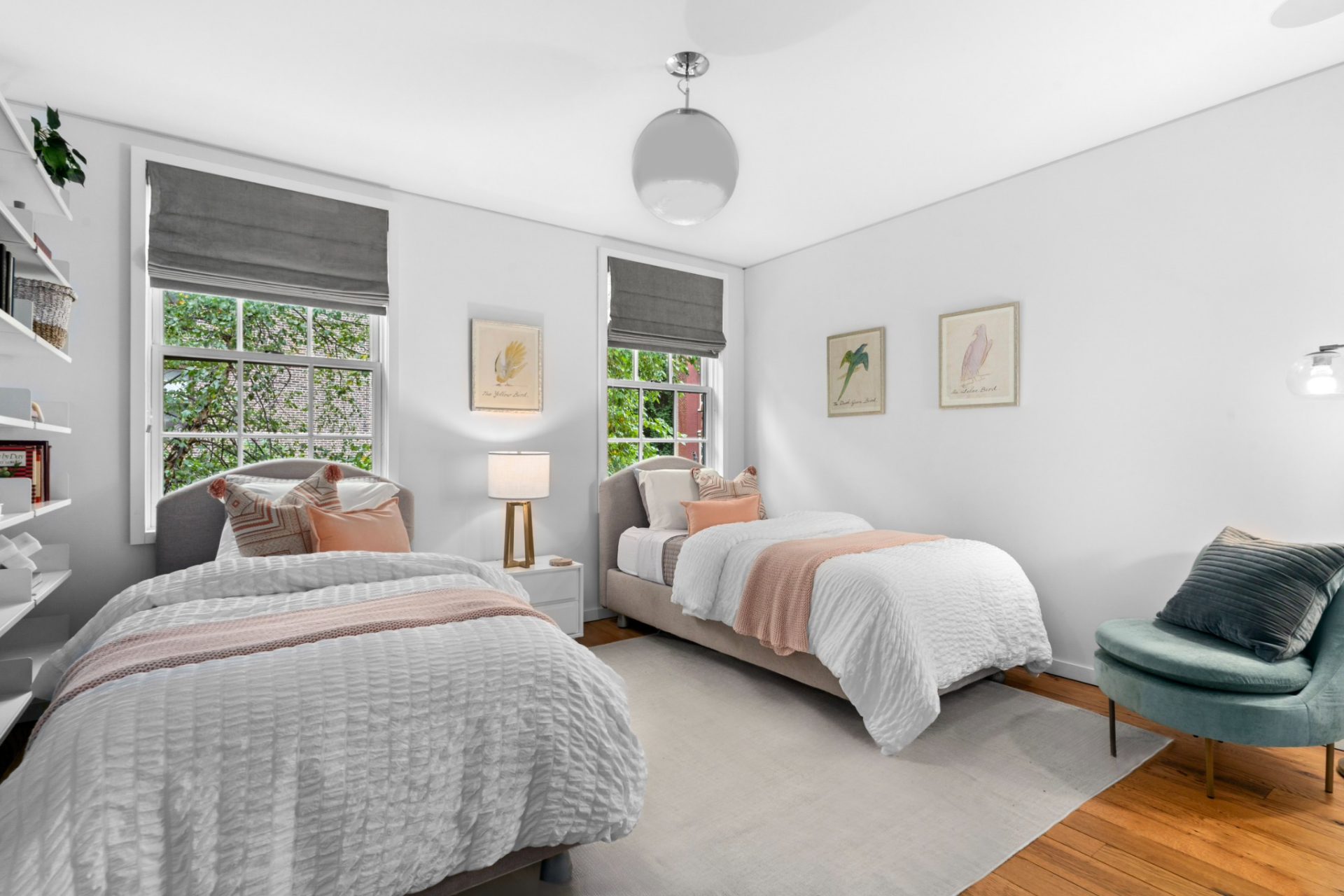 The first suite has a lighter, more neutral design, centered around two twin beds framed by soft textiles and simple decor.