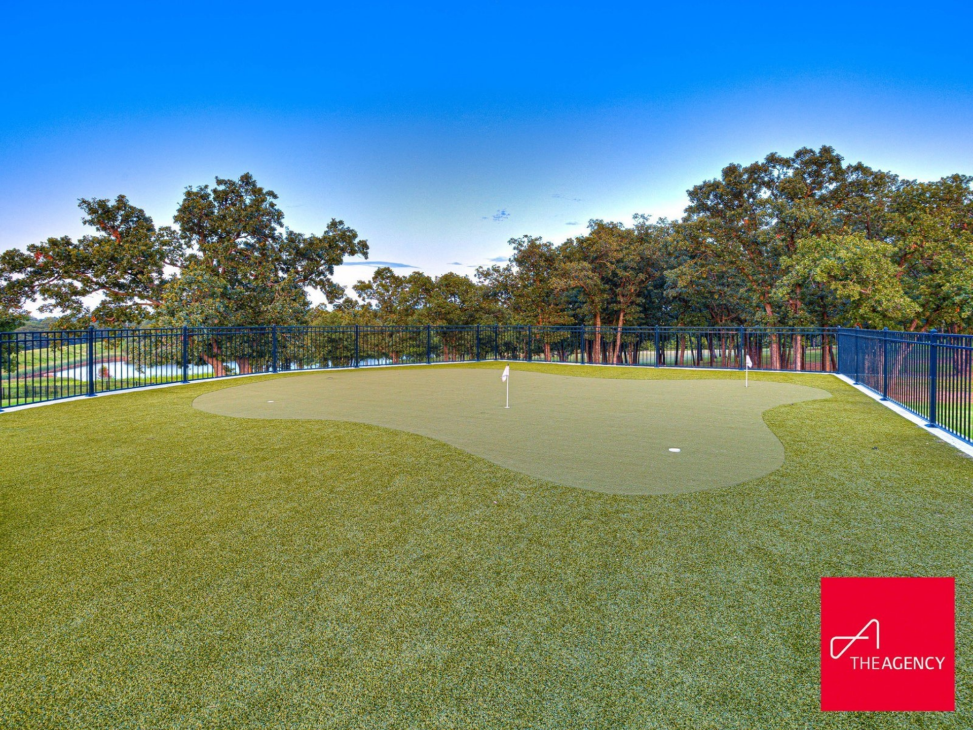 Tucked along the fenced lawn, the private putting green features multiple holes and gentle contours for short-game practice.