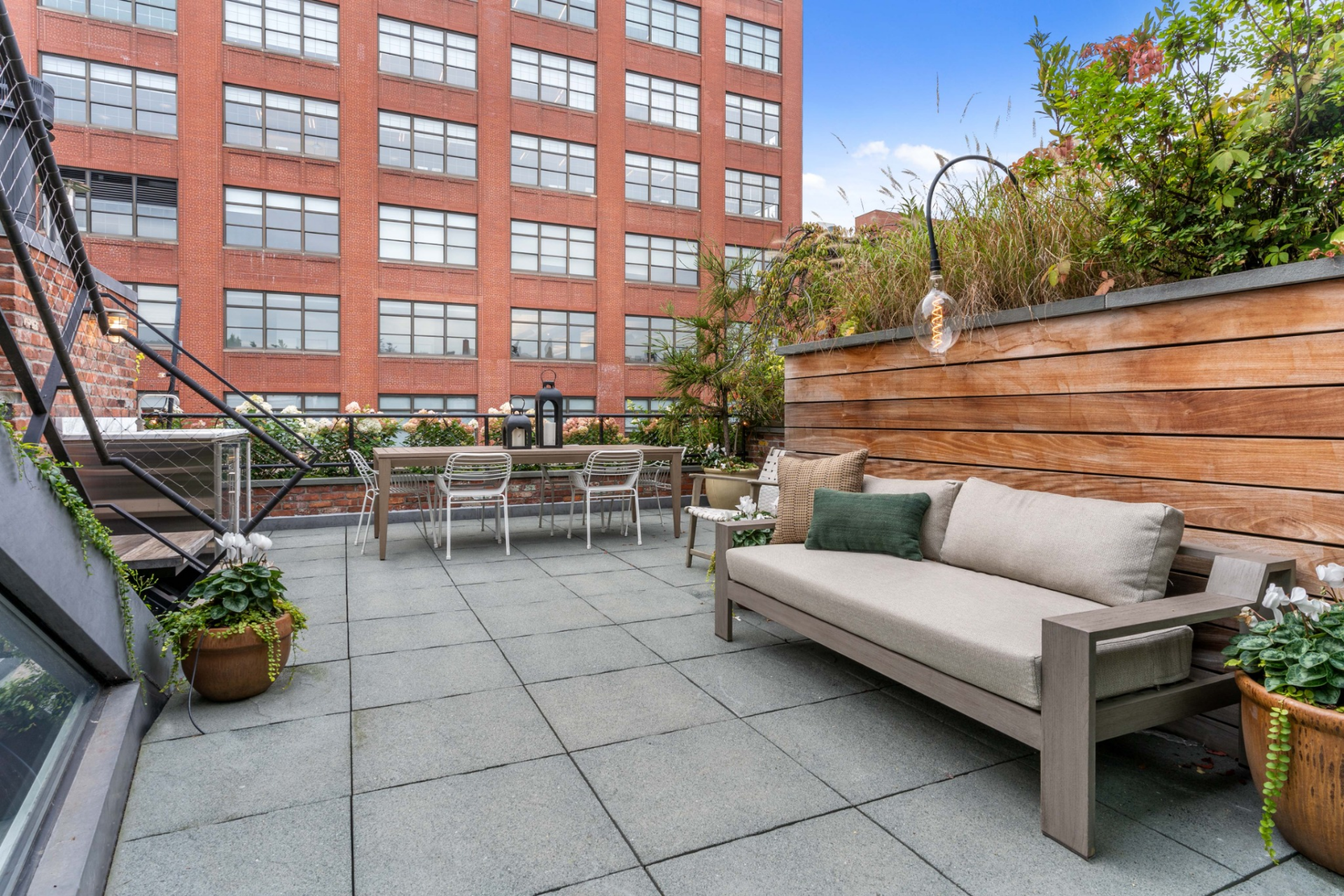 Stainless steel appliances and counter space run along one side, while open seating areas and dining zones spread across the terrace.