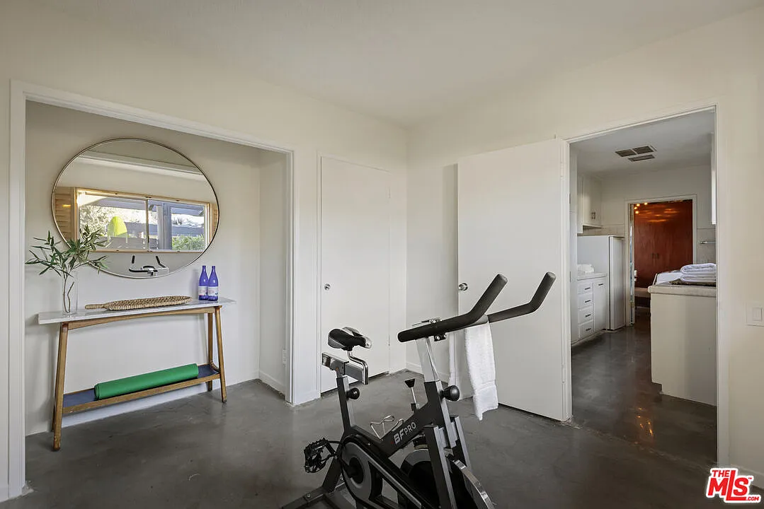 Set within a bright, open area, the workout space sits just off a connected room, allowing it to function as a flexible extension of the home.