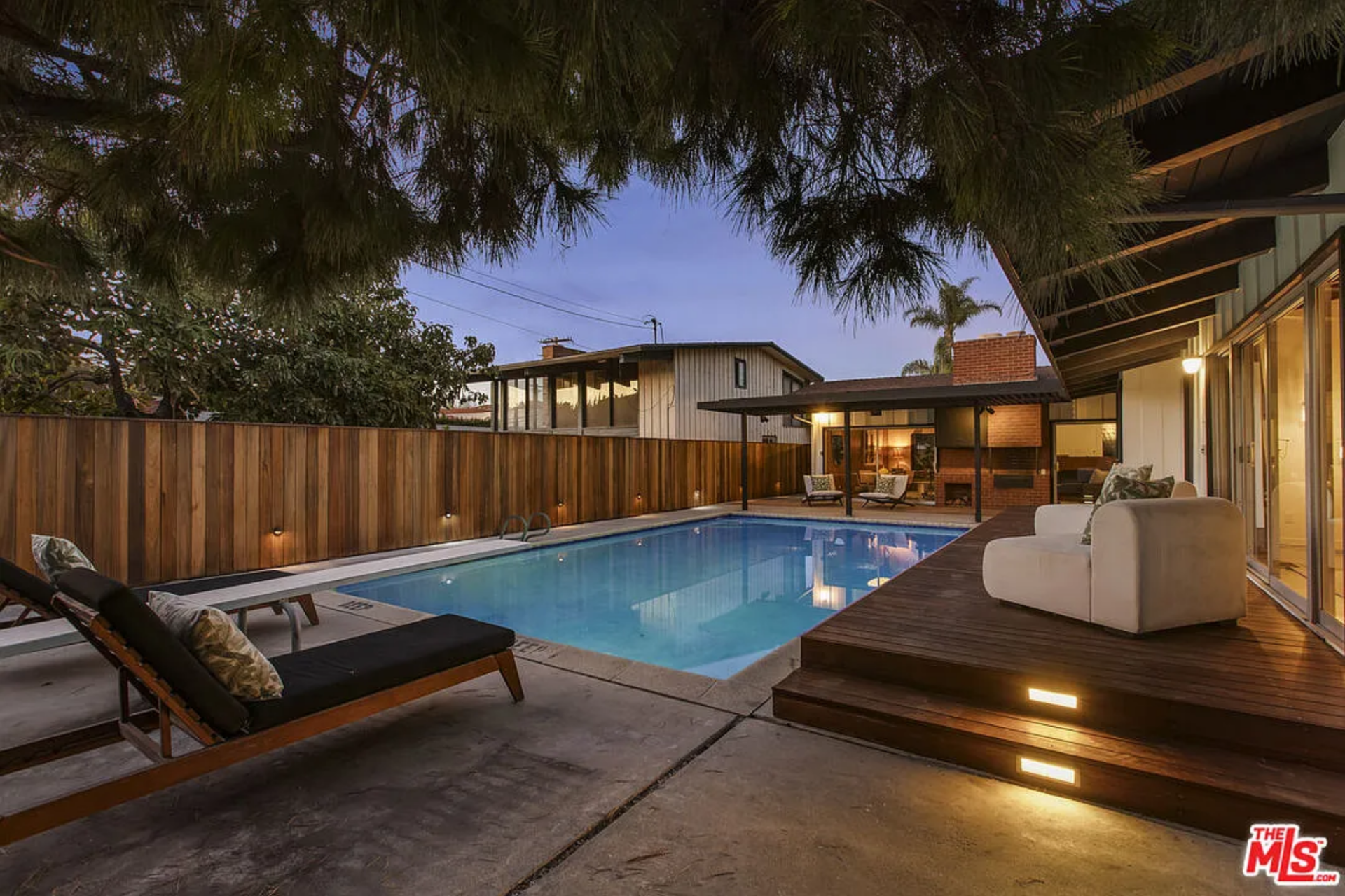 Just off the main living spaces, the pool is framed by a wood deck and lined with sliding glass doors, keeping it closely tied to the interior. 