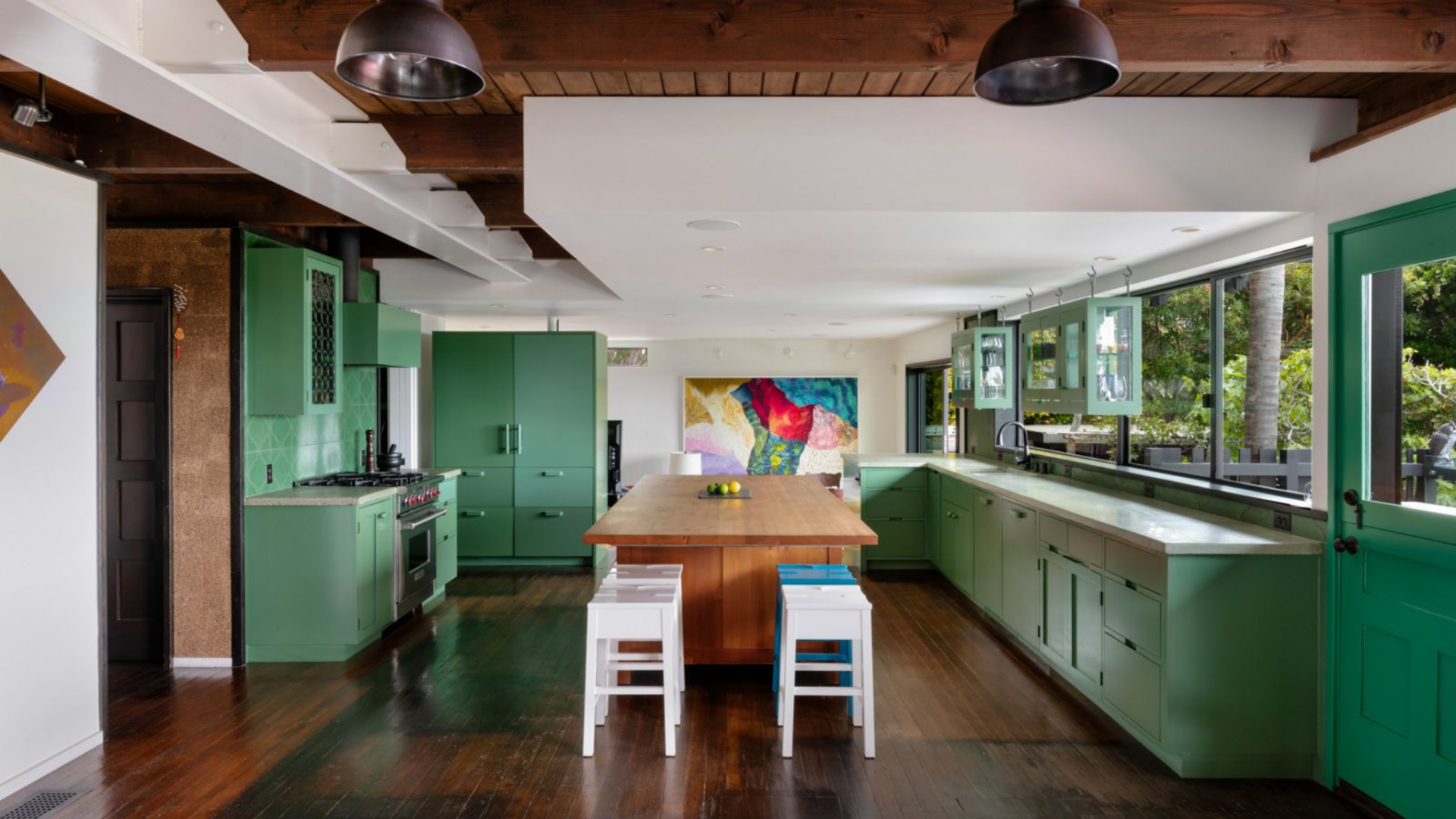 Updated with premium appliances and stone countertops, the space balances clean lines with warmer materials, most notably through a large butcher-block island that doubles as a prep area and casual gathering point.