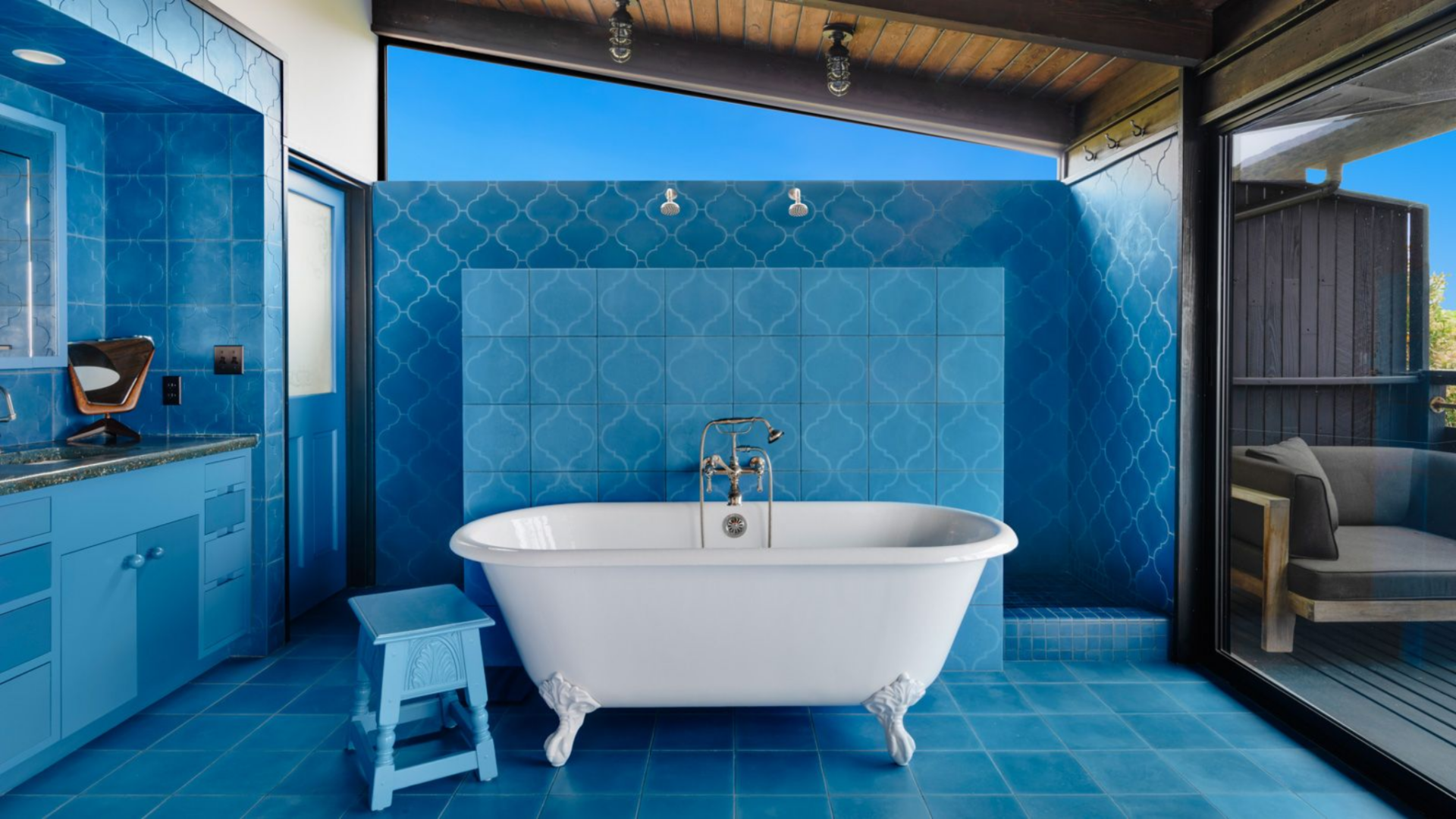 Just off the bedroom, this bathroom is fully wrapped in blue tile, creating a bold contrast against the neutral tones of the bedroom.