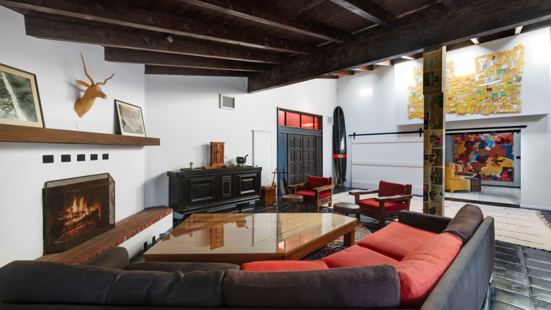At the center of the wing, the fireside lounge centers around a built-in fireplace with a raised brick hearth and a simple wood mantle above.