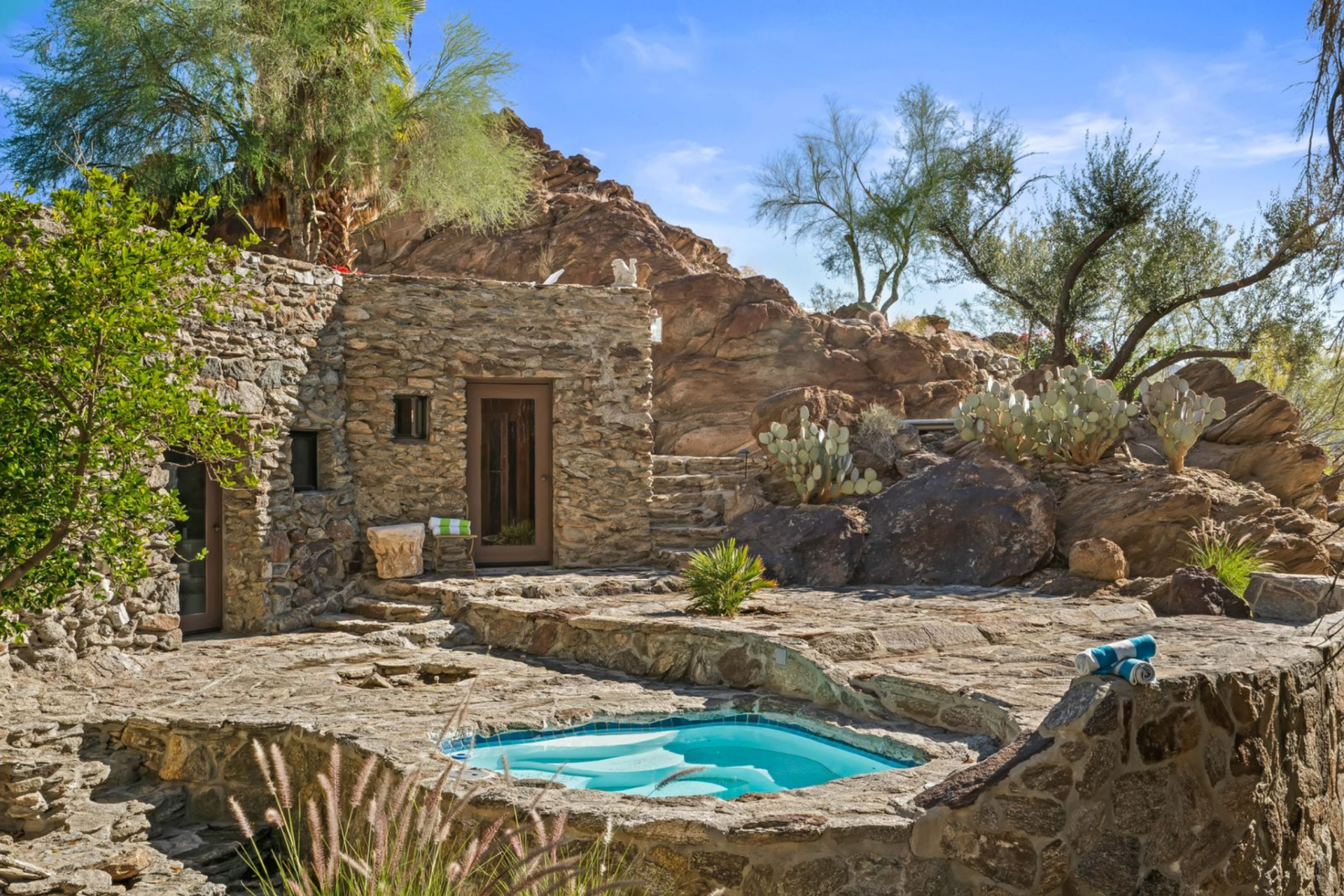 Constructed with stacked stone that blends into the surrounding terrain, it sits elevated above the property with its own privacy and views.