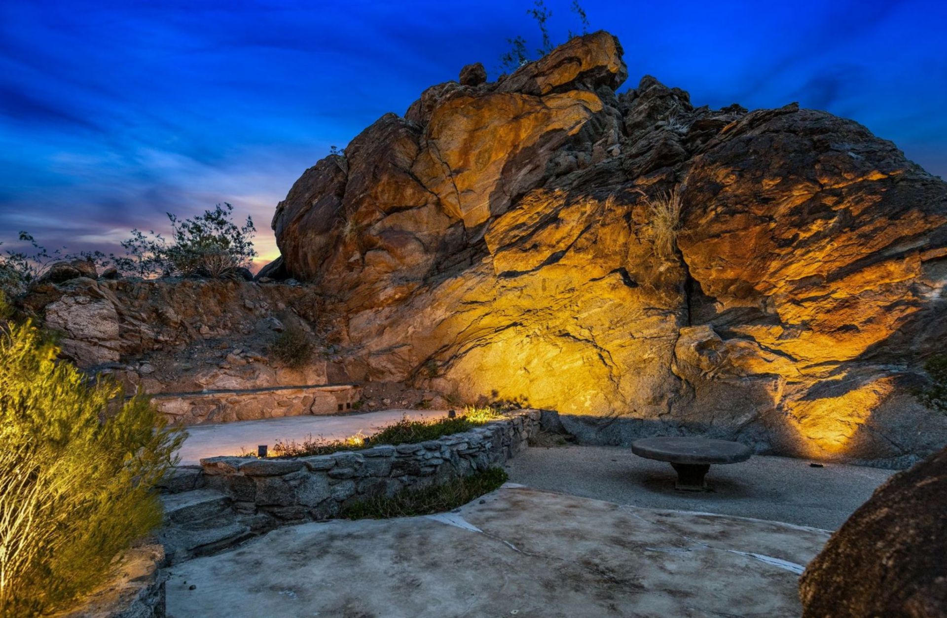 Carved into the natural rock, the amphitheatre consists of a curved stone stage and surrounding seating built into the terrain.