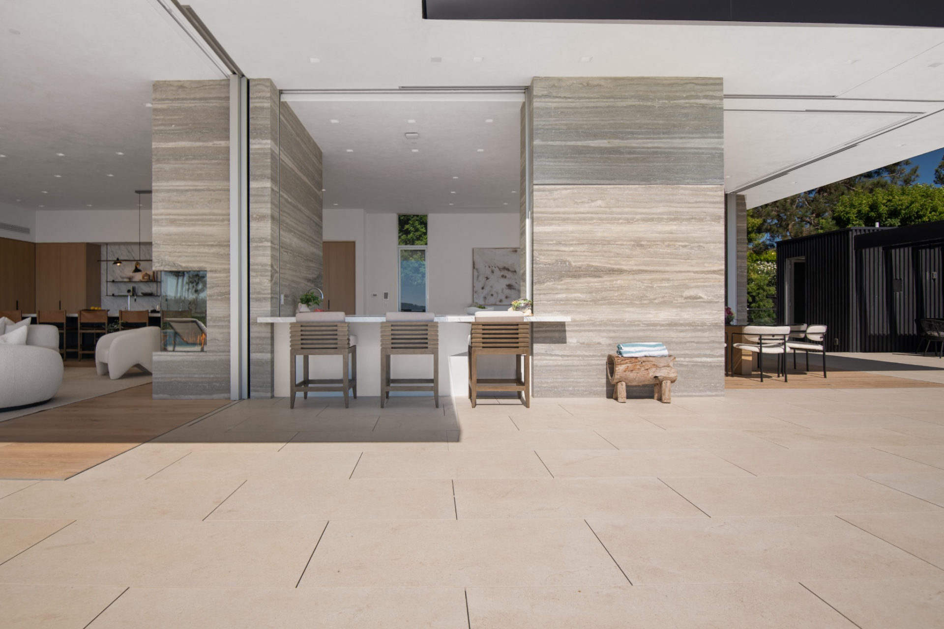 On the terrace side, that same counter becomes an outdoor bar positioned between the pool deck and the covered lounge area.