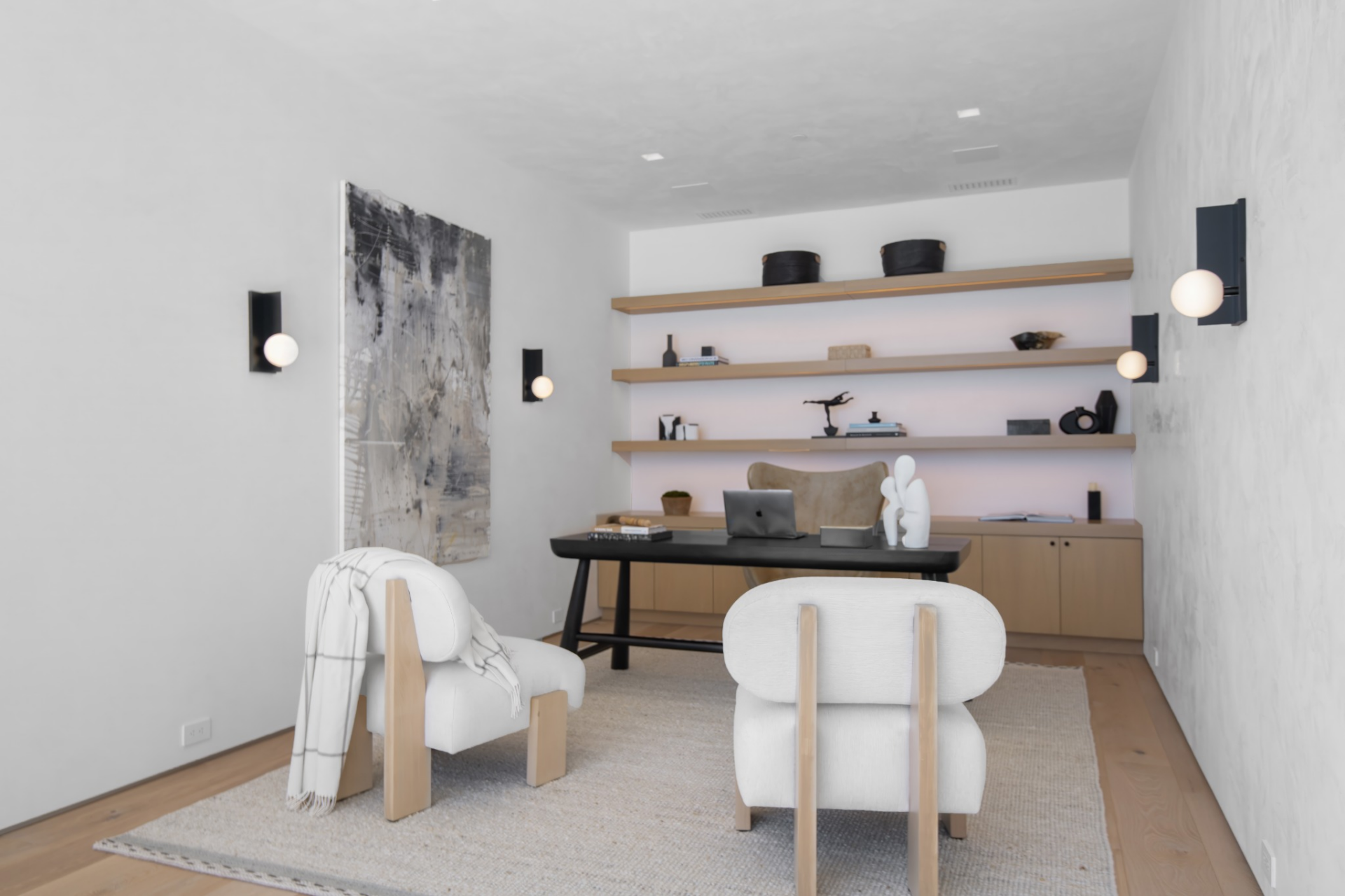Inside, the room is fitted with a built-in desk, floating shelves, lower storage, and a pair of lounge chairs.