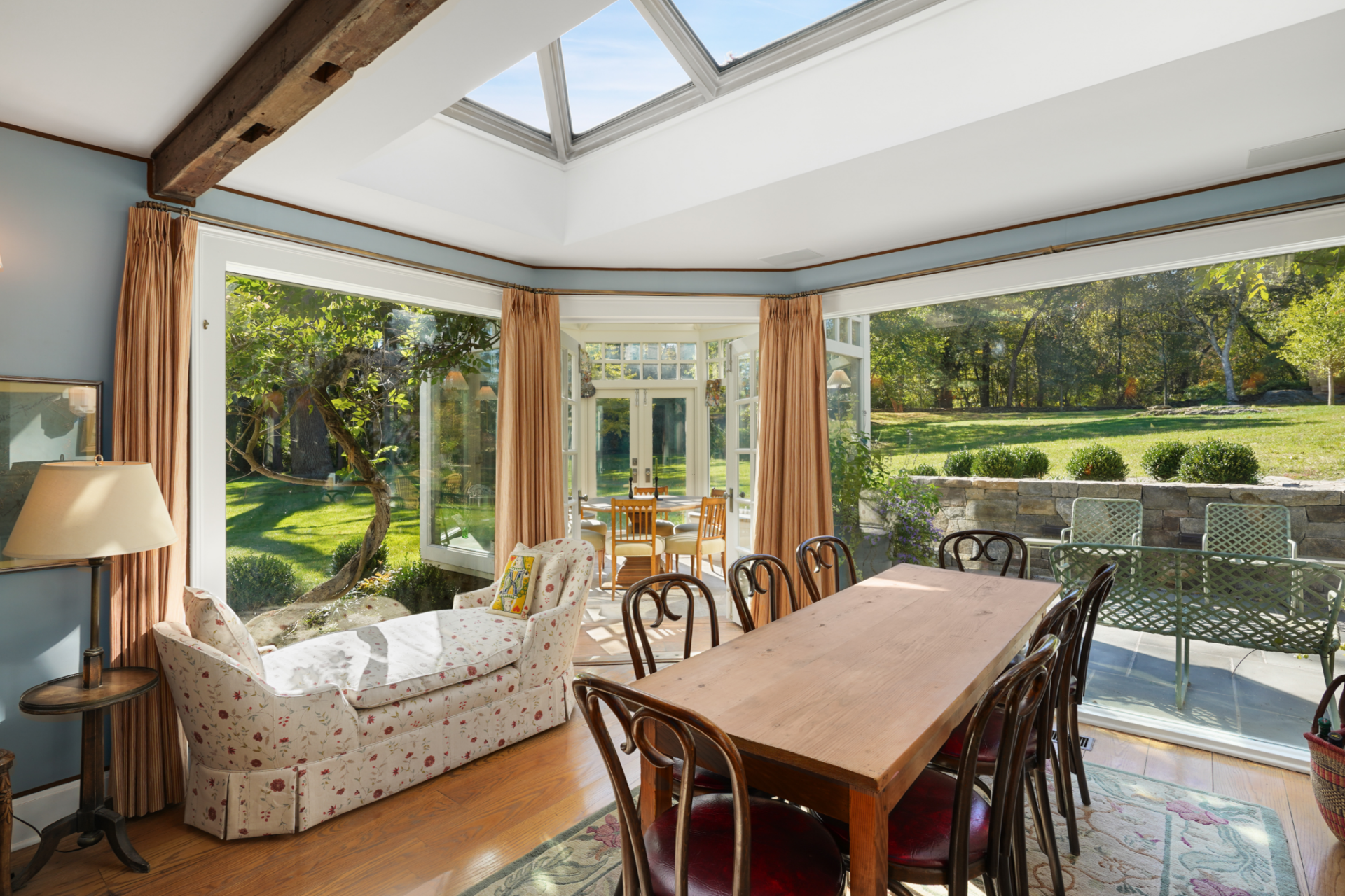In the next room, the main dining area opens up as a bright garden-facing space centered around a long wood table and a row of bentwood chairs. 