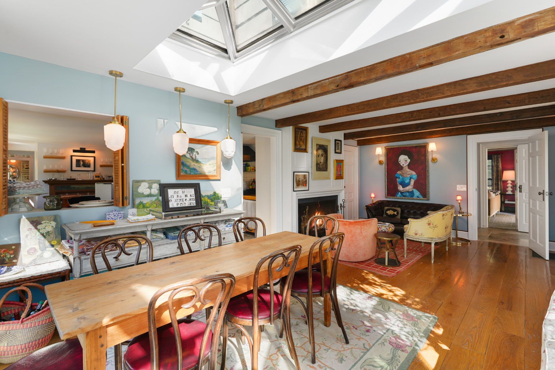 At one end, the dining space blends into a smaller sitting area with its own fireplace, making the room feel less formal and more like a connected gathering space that can shift between meals and conversation.