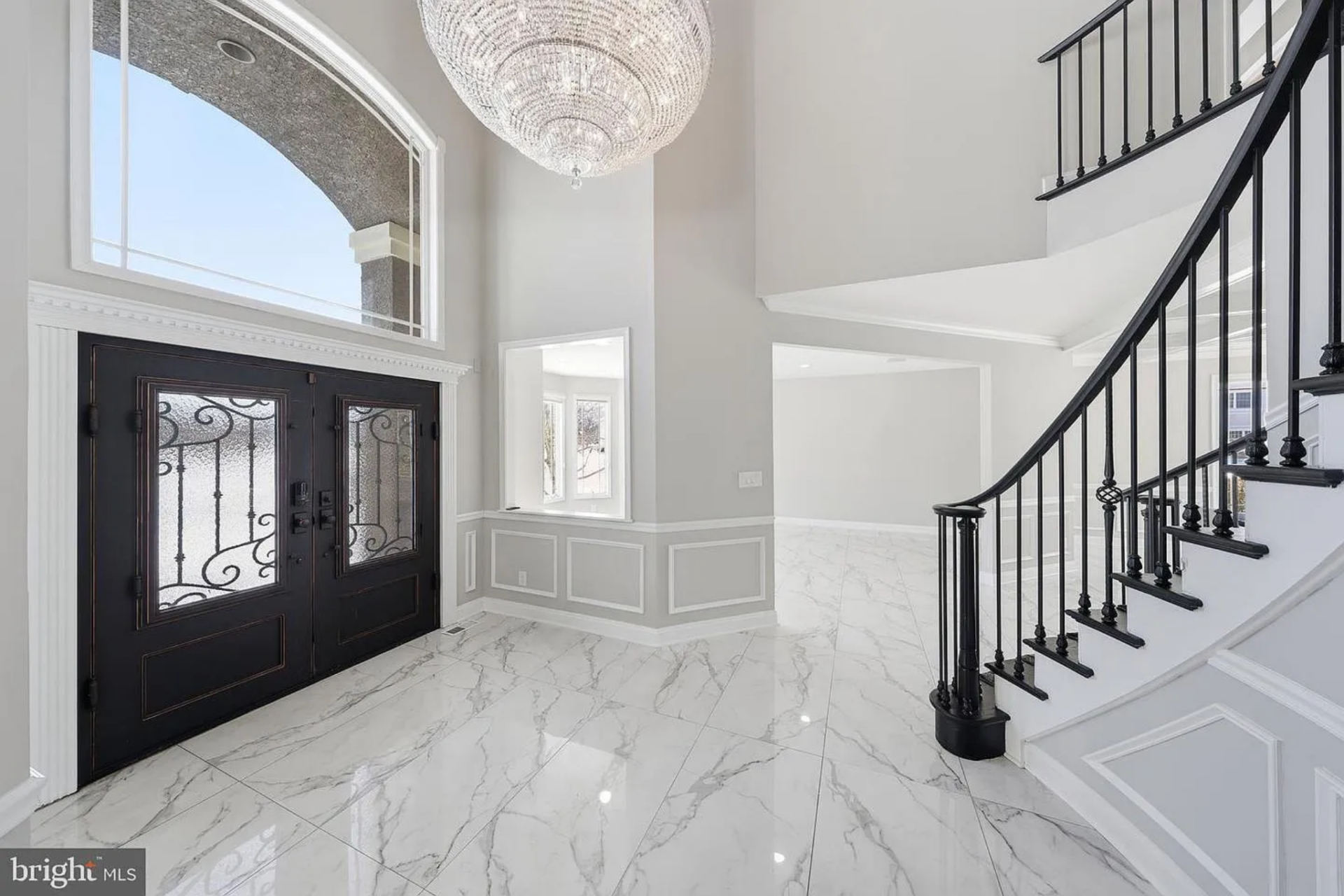 Walking through the double front doors of Cox's New Jersey home, the house opens to a soaring two-story foyer beneath an oversized crystal chandelier, its light reflecting across polished marble floors laid in a bold, veined pattern.