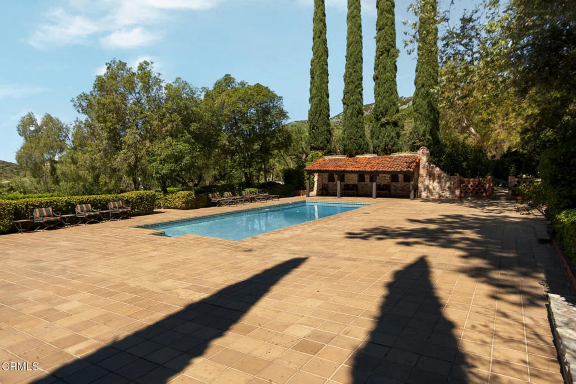 Outside, the residence has its own large pool terrace with a rectangular pool set into a broad field of tan tile. 