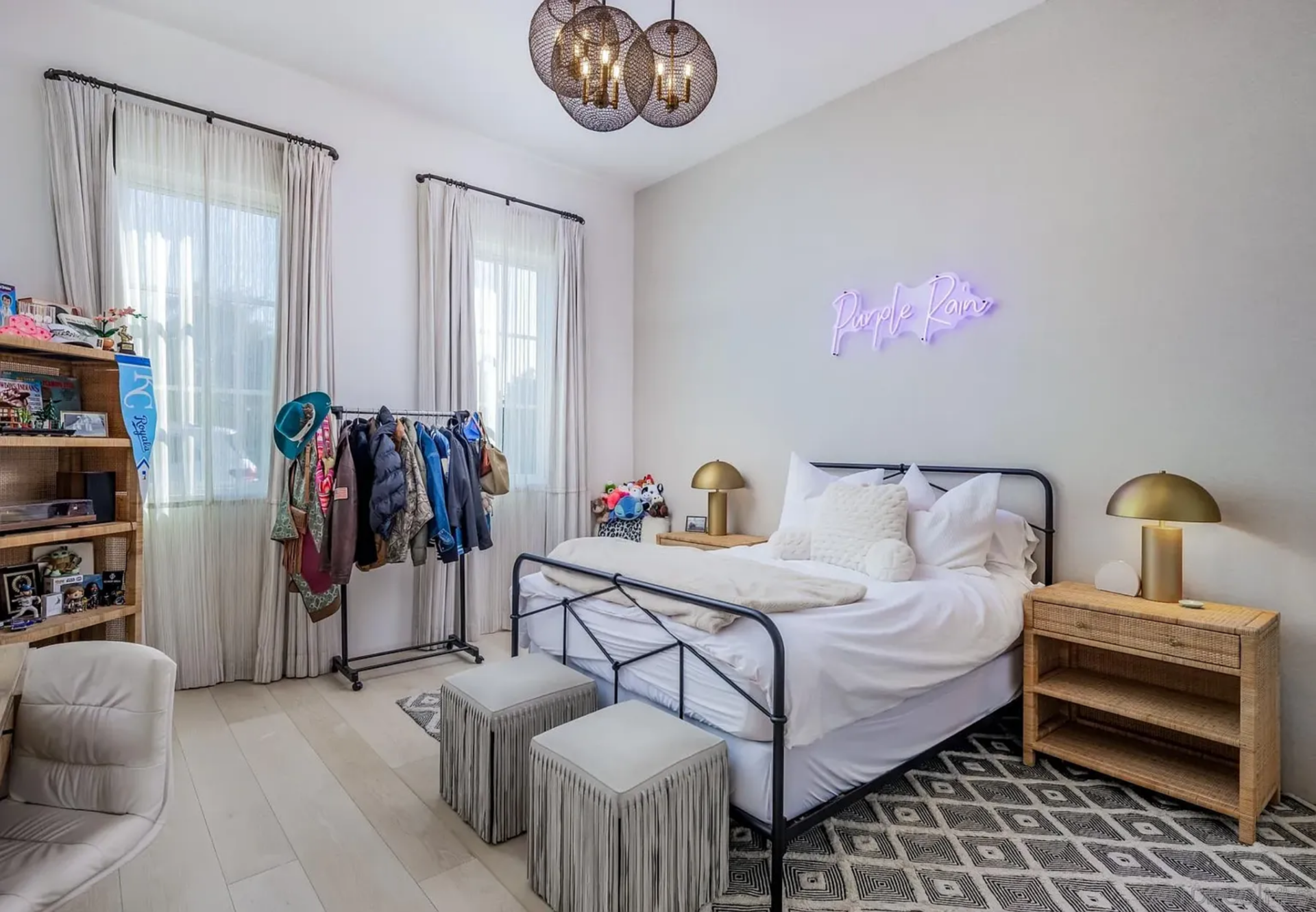 The first bedroom feels a little more casual and personalized, centered around a black metal bed dressed in crisp white bedding. 