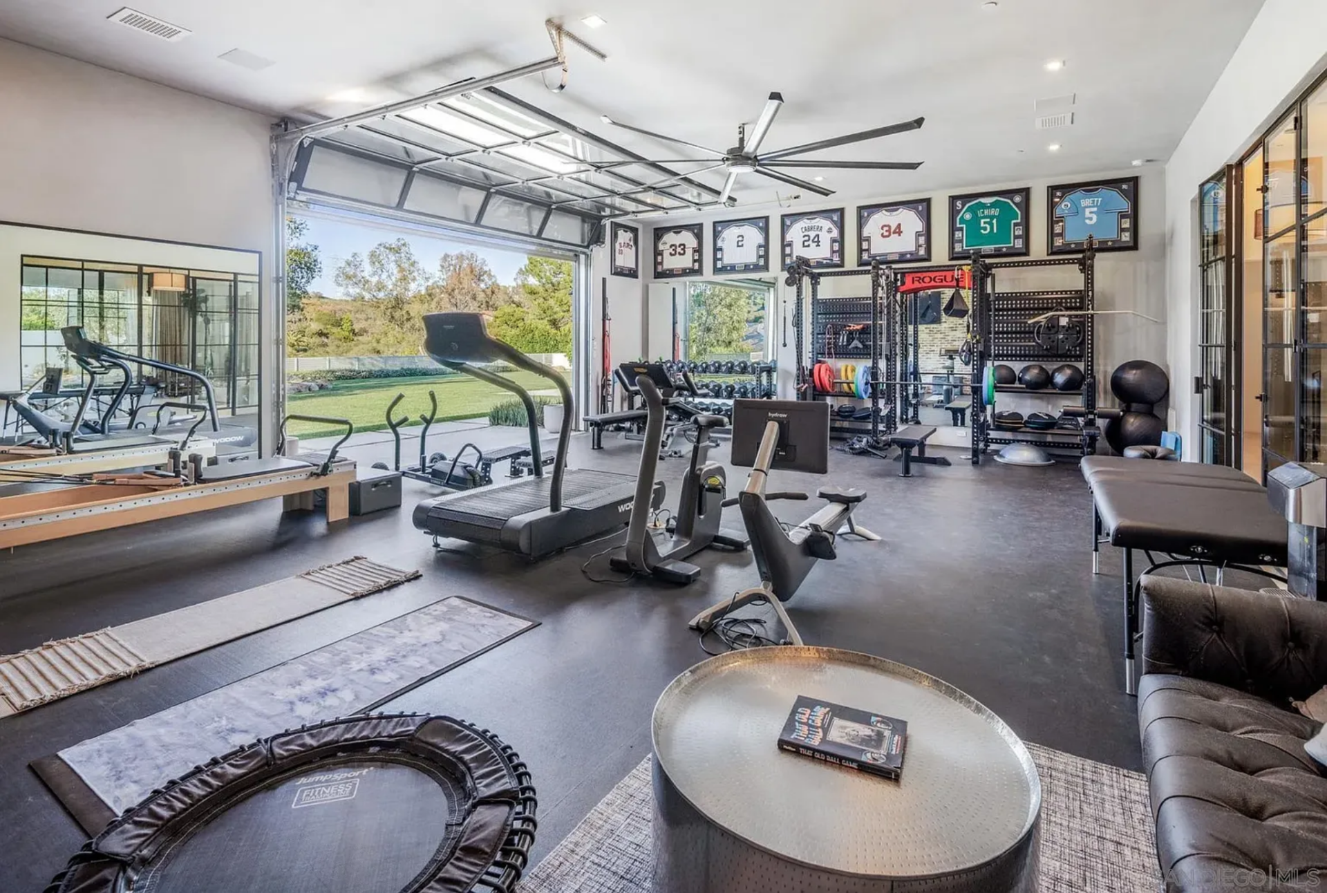 The gym is set up as a full training facility, with cardio machines, reformers, free weights, and strength equipment spread across a wide-open layout. 