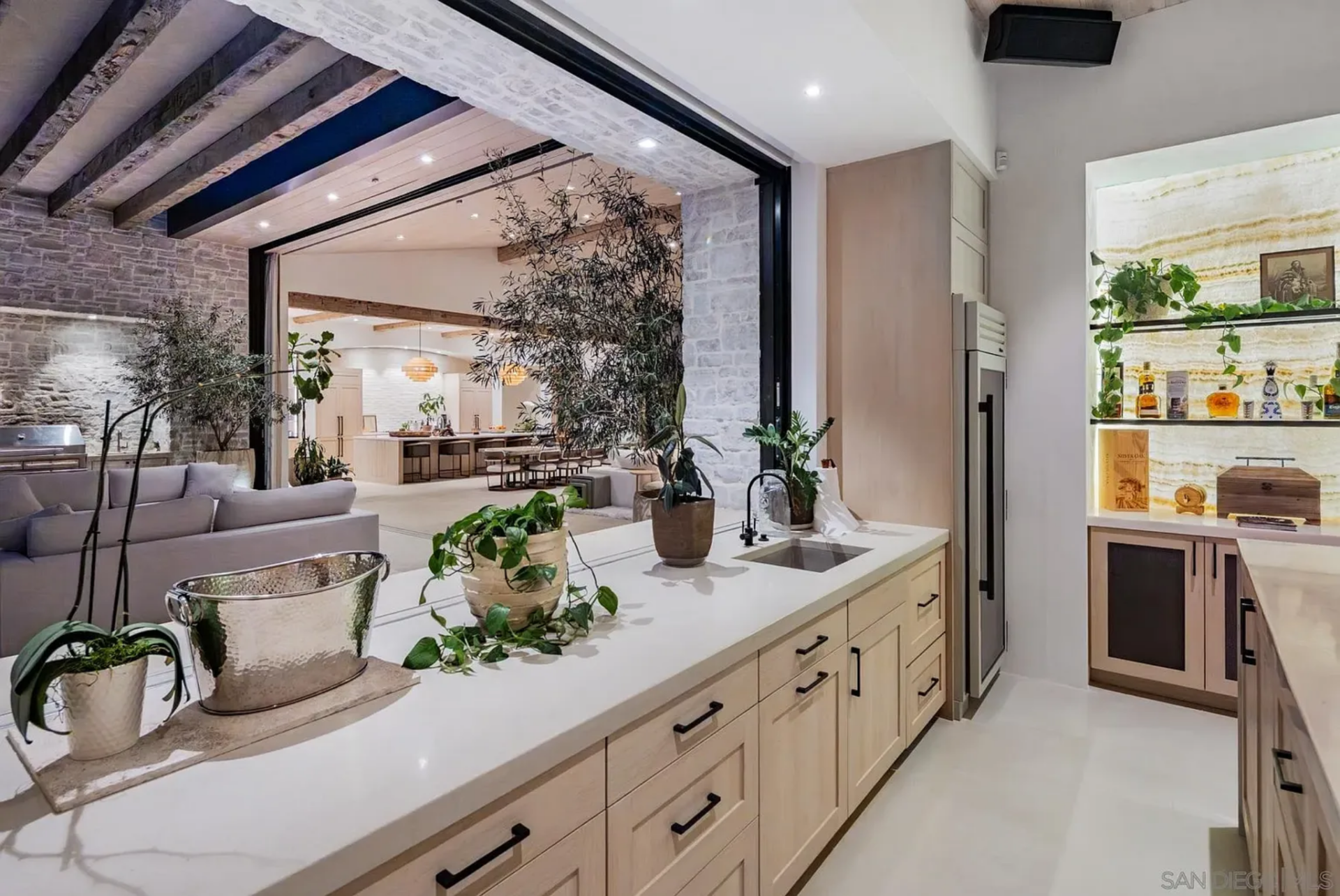 What makes it stand out is the pass-through opening and direct connection to the patio, allowing the space to work just as easily for poolside gatherings as it does for parties inside.