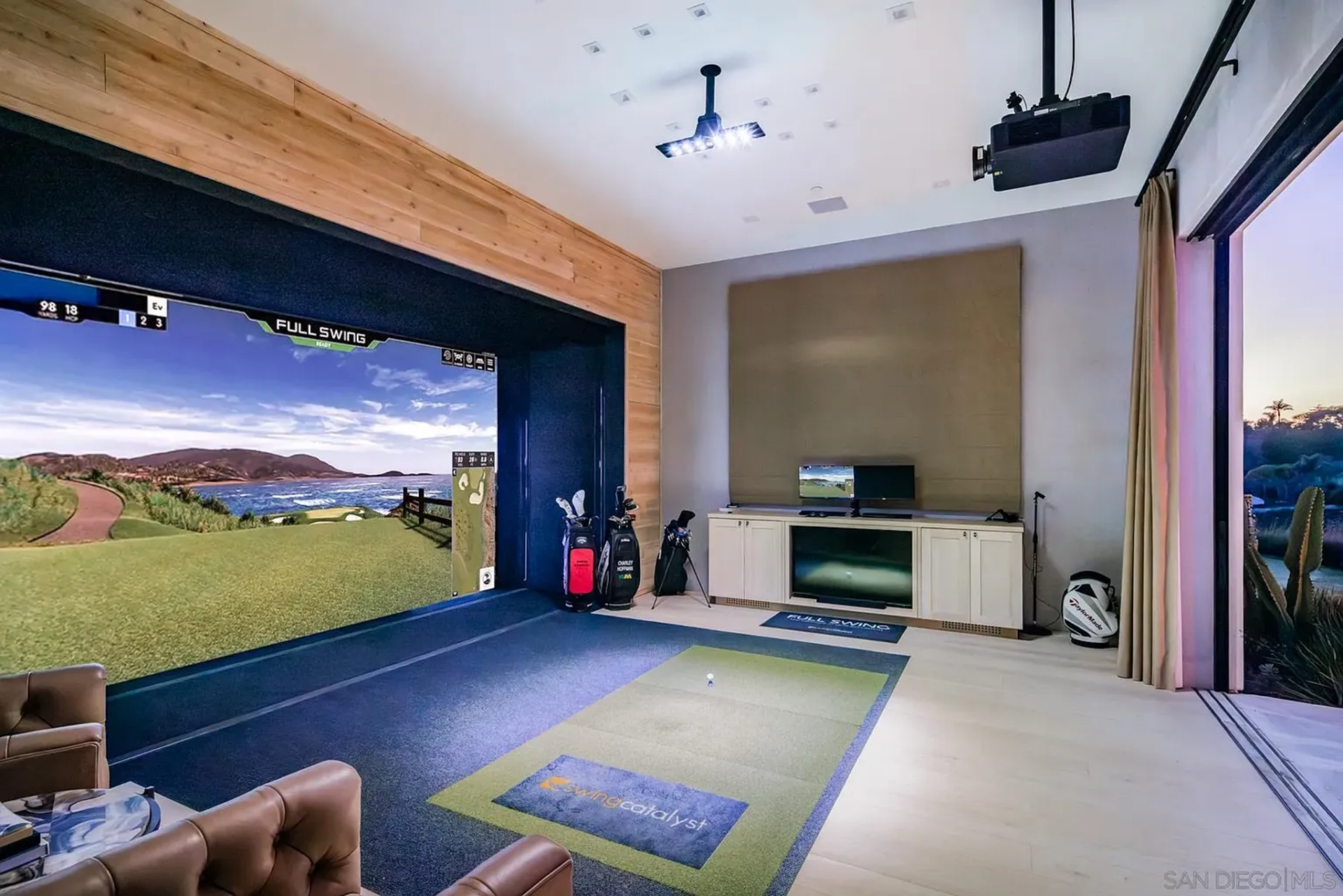 The golf simulator turns one of the home’s leisure spaces into a practice room, with a full projection screen, hitting area, and room to swing without it feeling squeezed in.